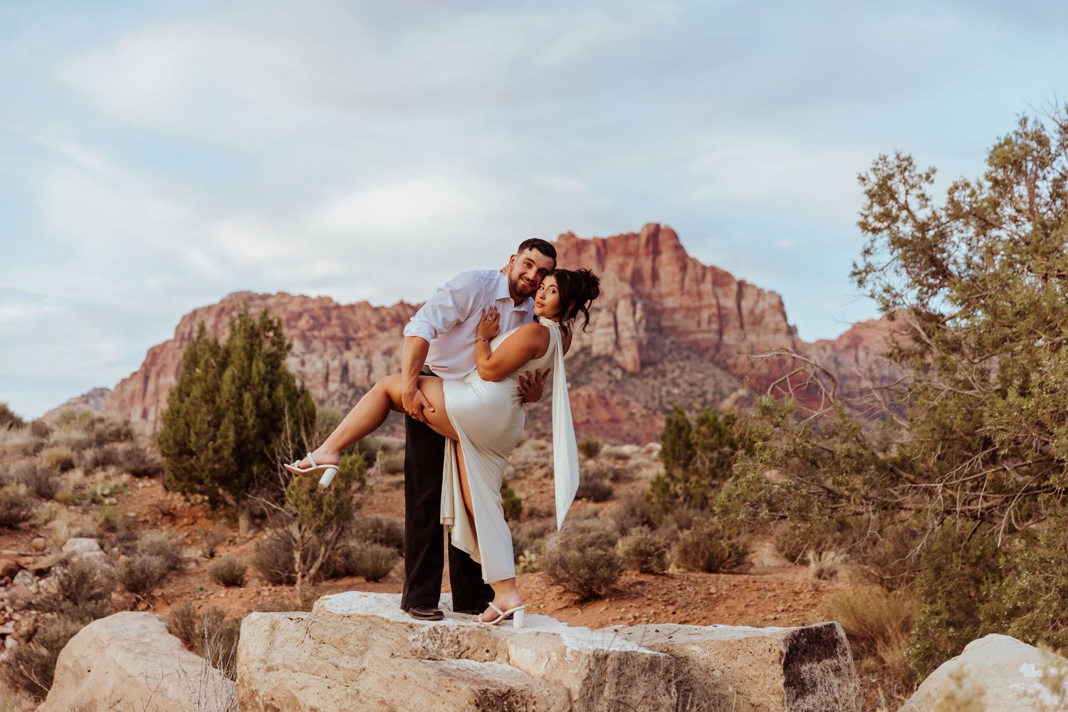 Desert engagement photos with red rock formations and desert vegetation in background.