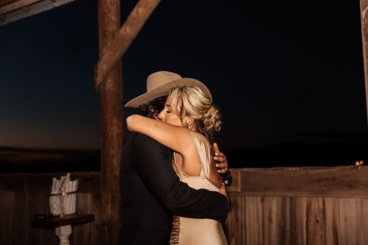 Couple dancing together at sunset in rustic barn venue.