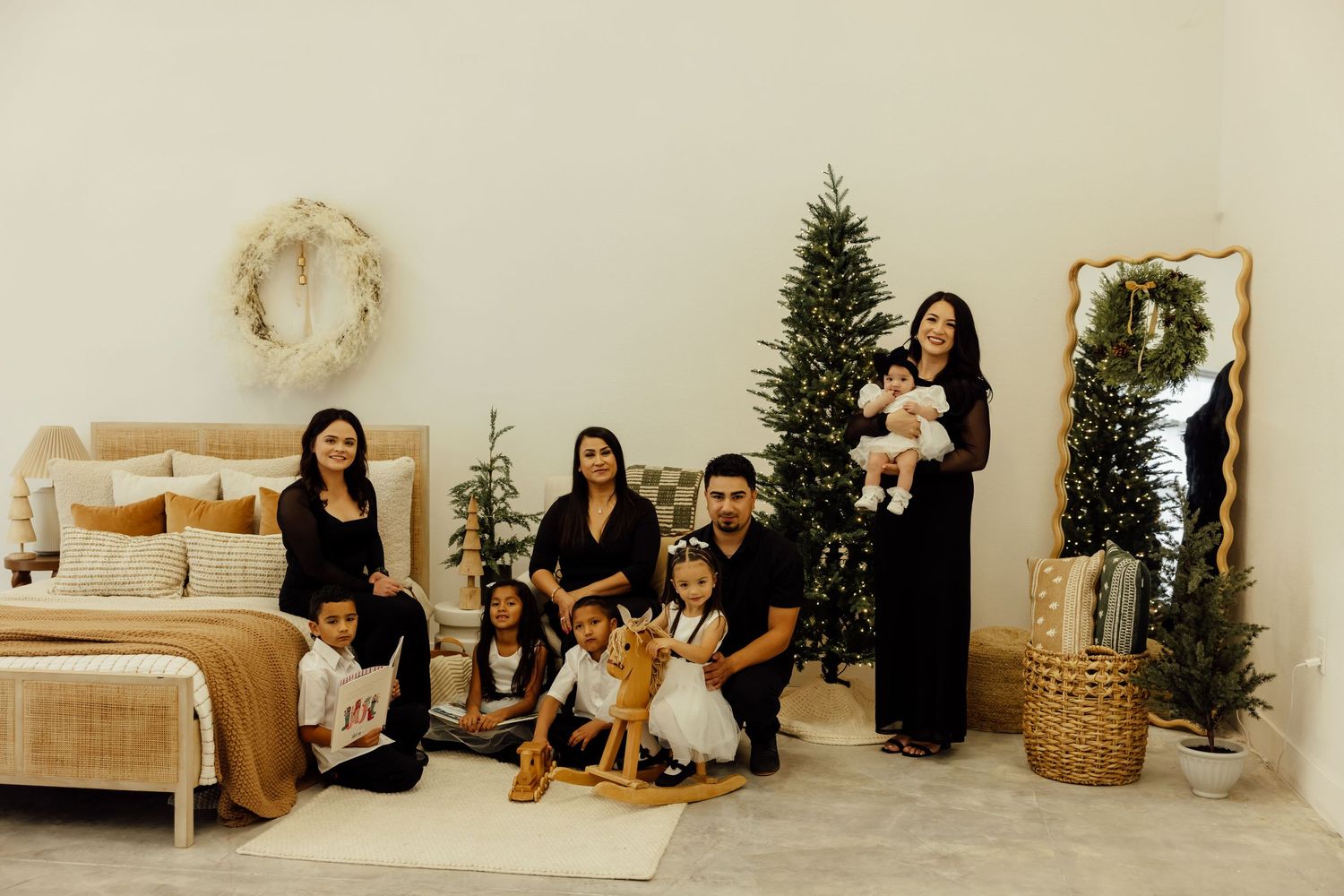 A bright studio space decorated for the holidays with Christmas trees and natural woven baskets.