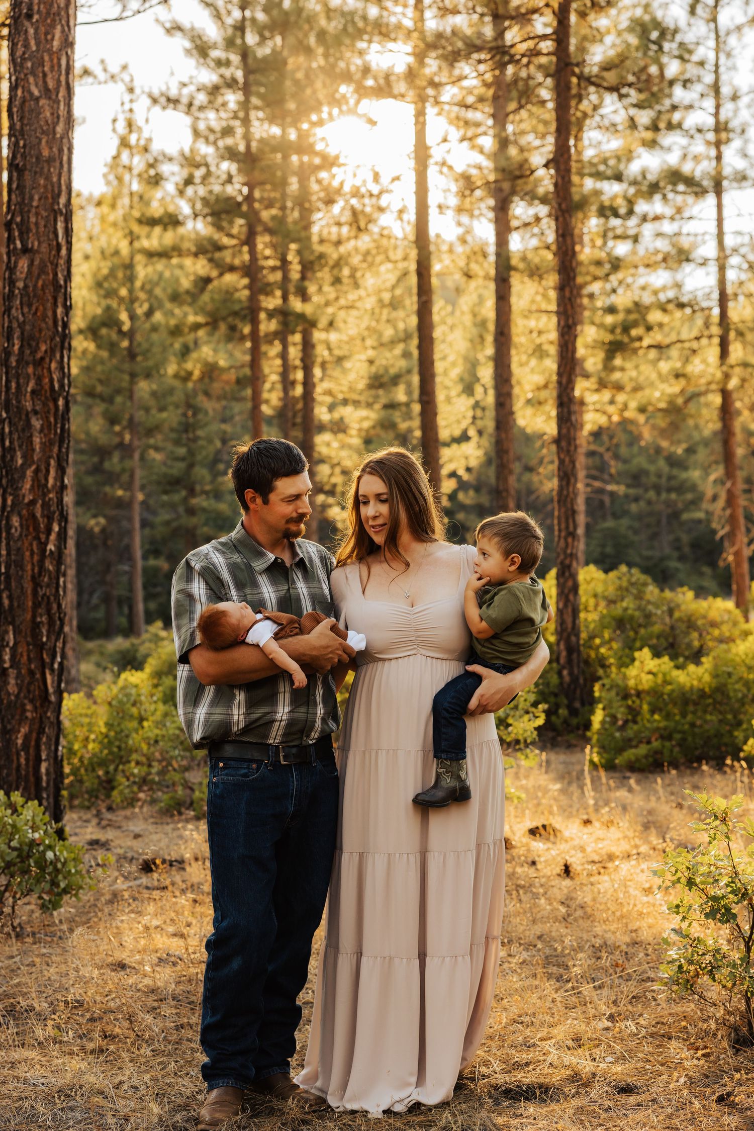 Family sharing joyful moments together in golden sunlit forest clearing.