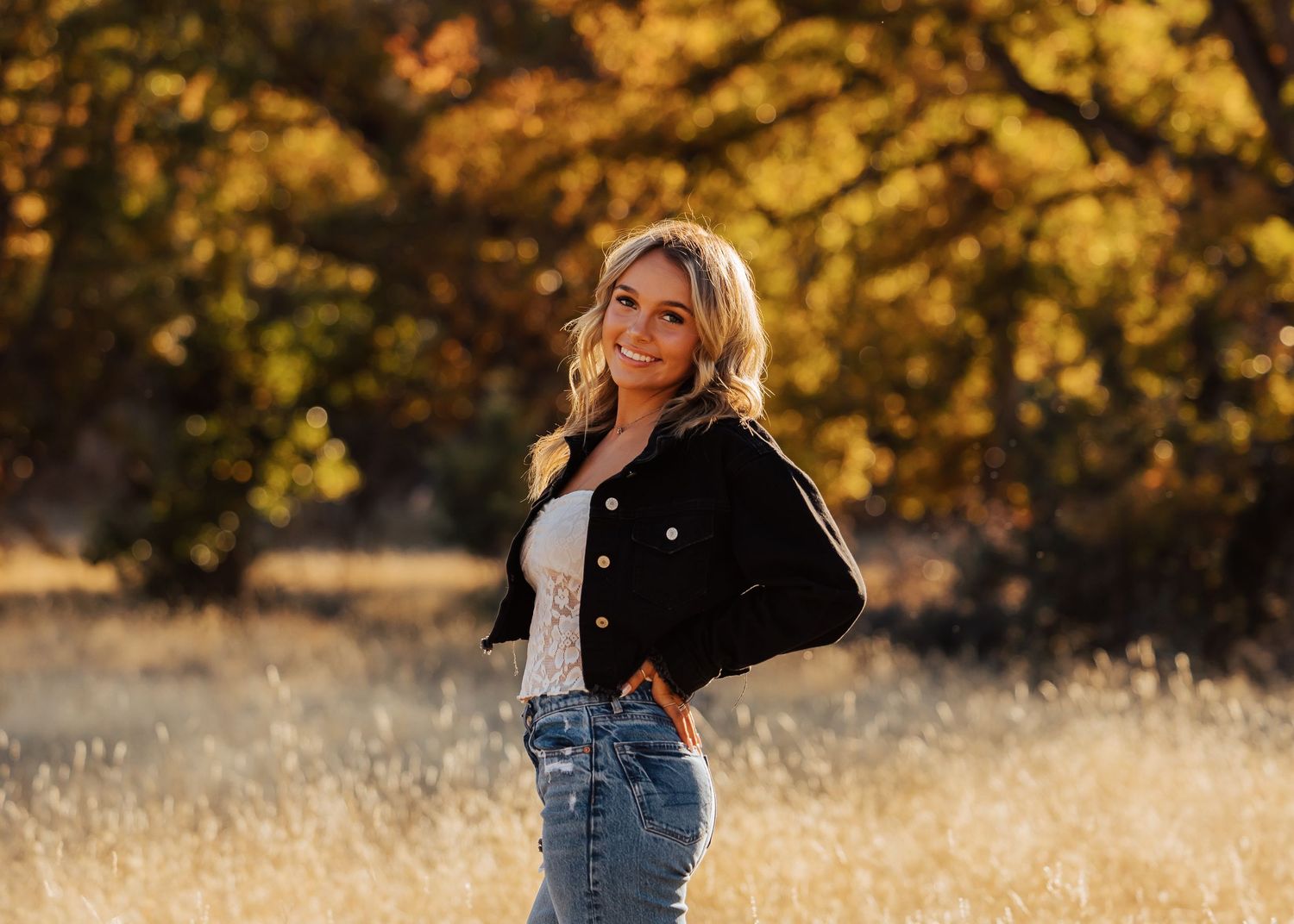 Natural outdoor portraits with golden autumn trees and tall grass.