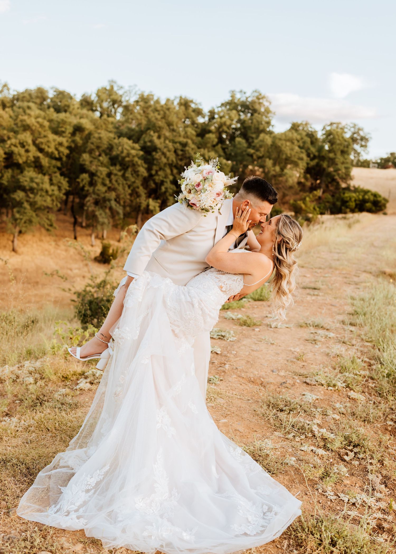 A couple sharing an intimate dance moment during their wedding photoshoot in a natural setting.