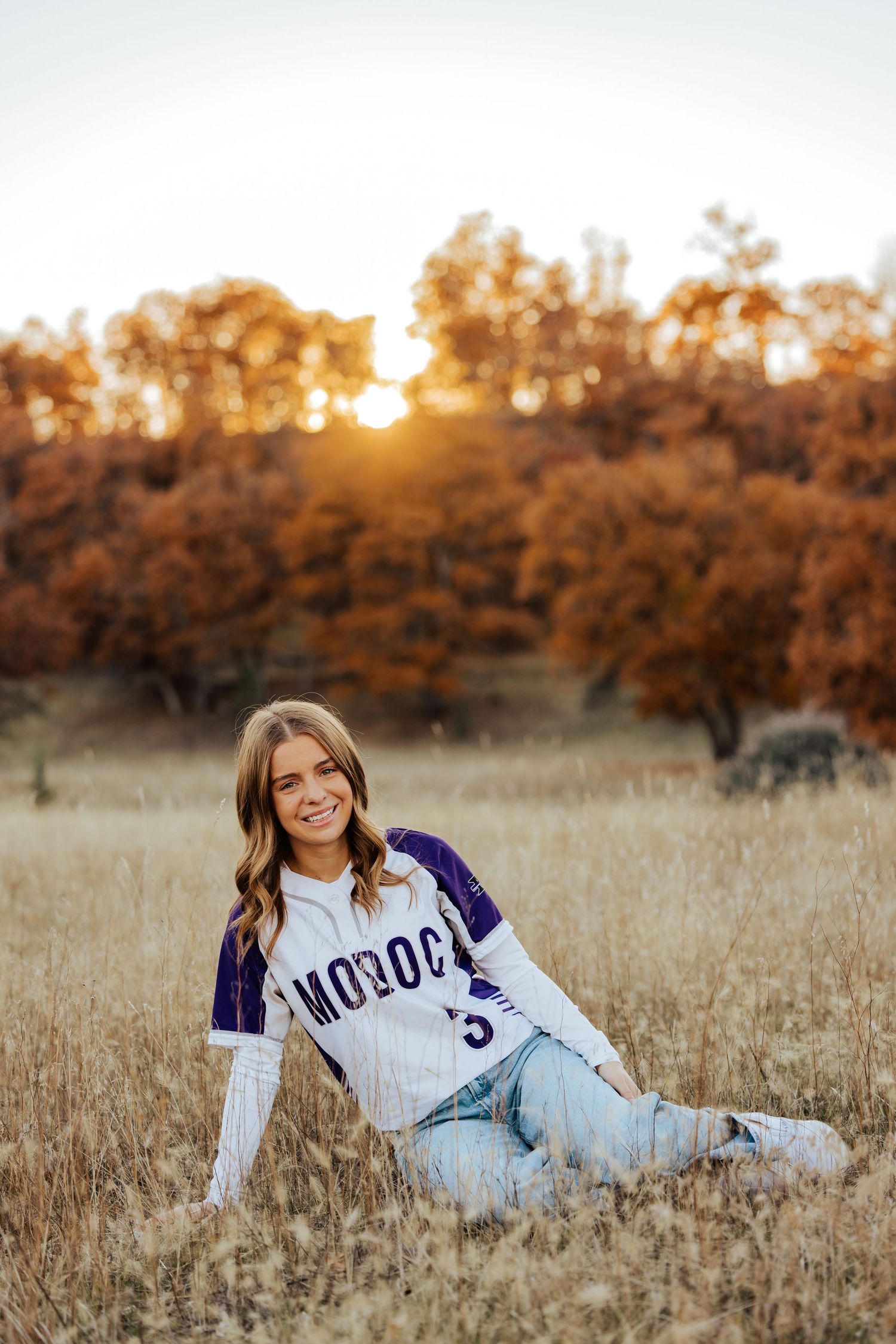 Athletic themed senior portrait session in golden autumn field.