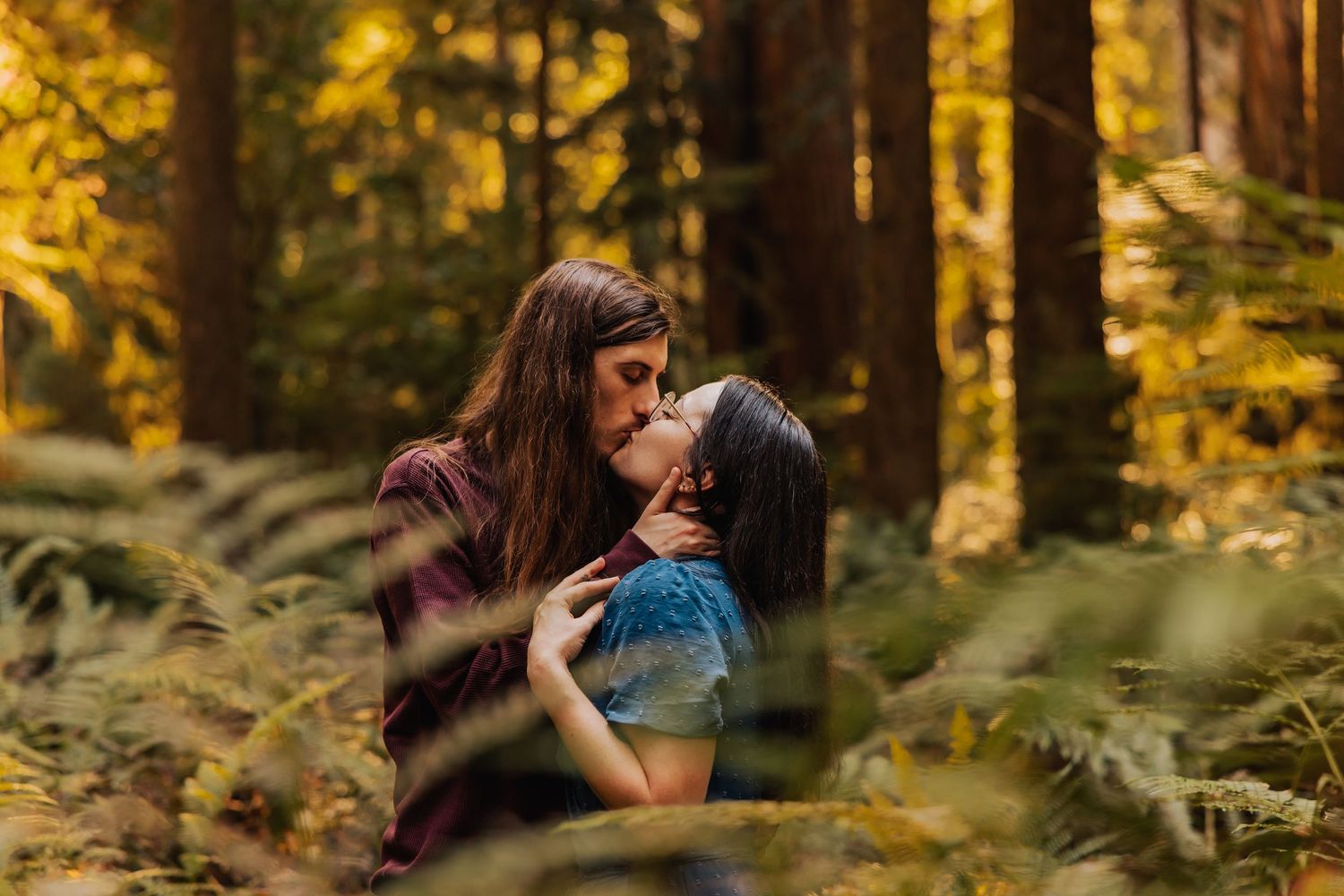 A romantic forest engagement session among towering redwood trees at sunset.