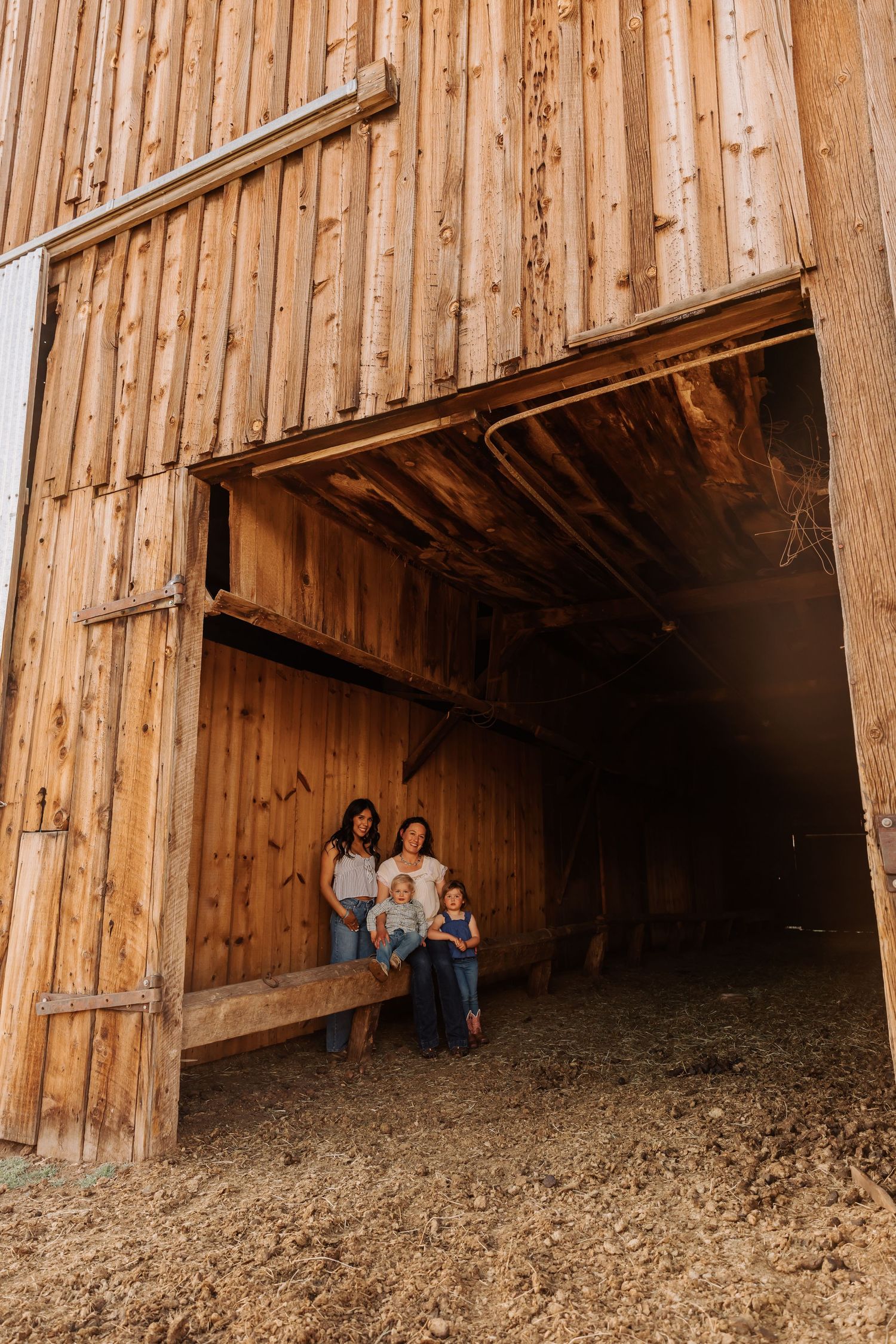 Interior of rustic wooden barn showing beams and natural lighting.