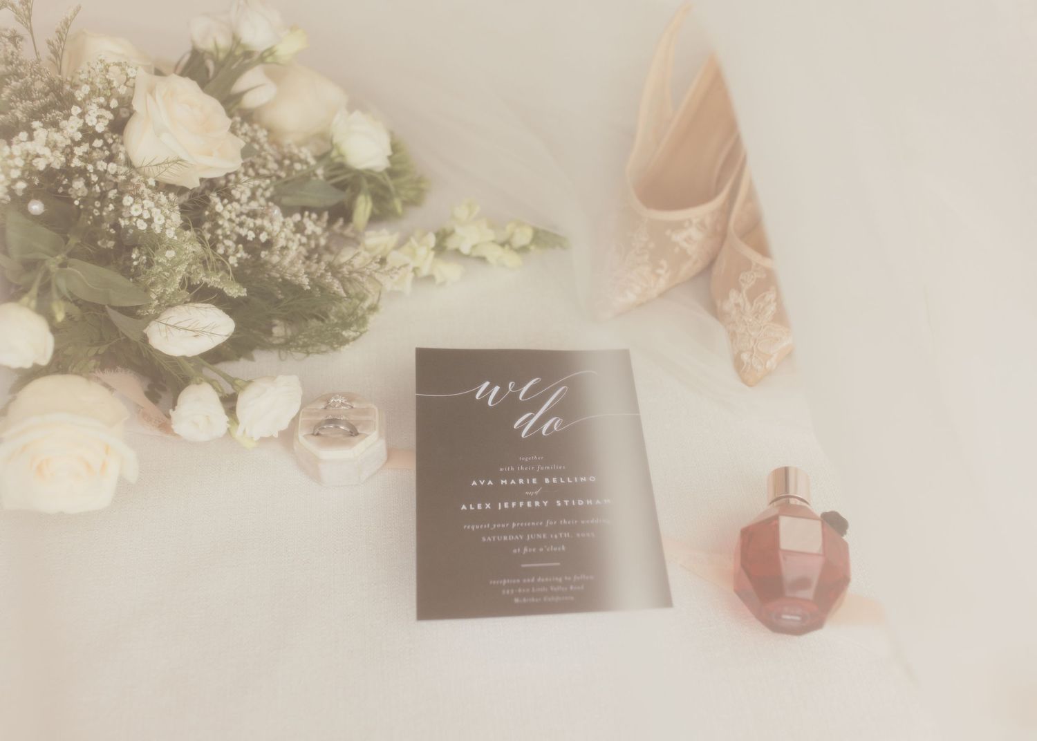 Wedding details including invitations, flowers and pink accessories on light background.