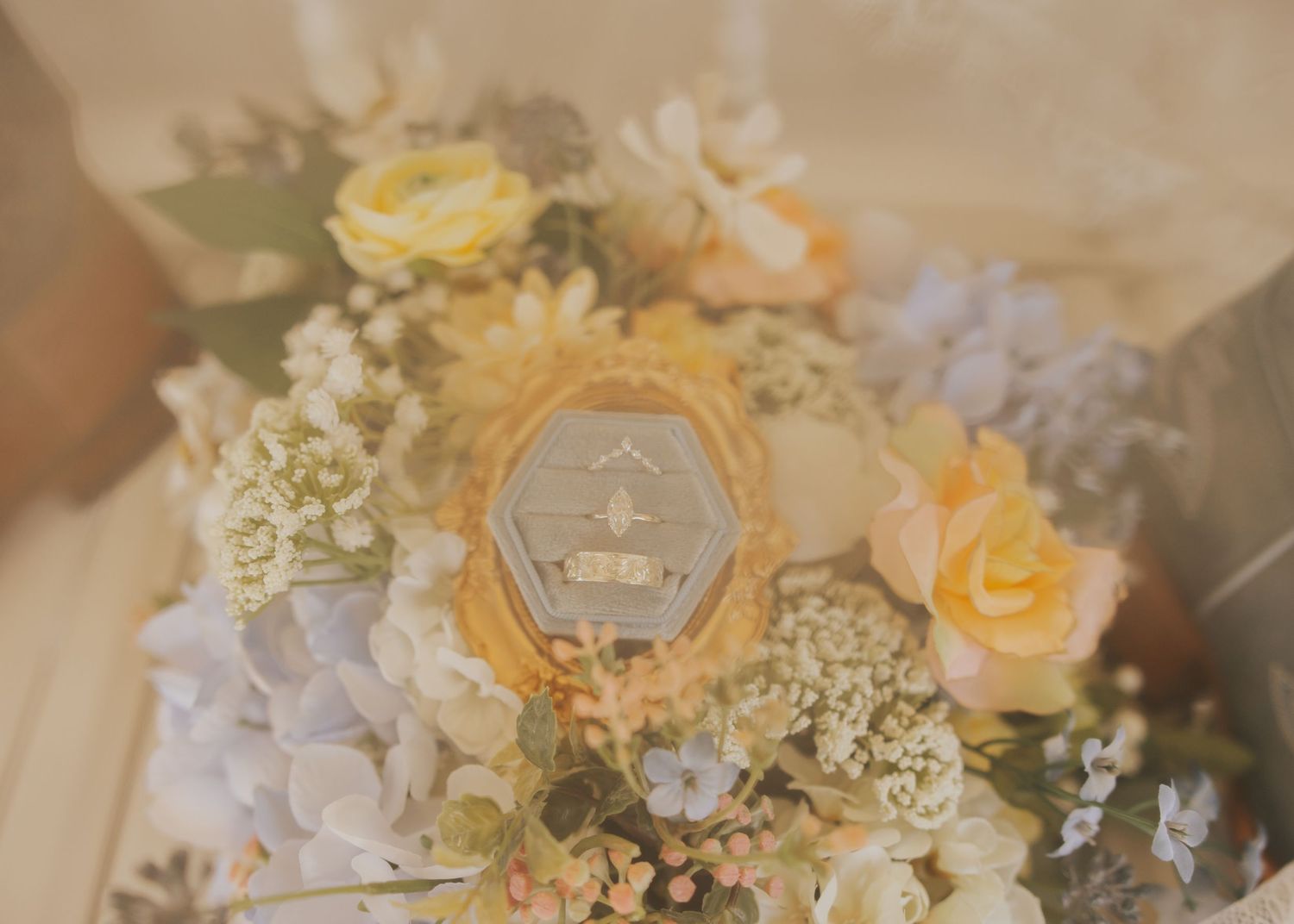 Close-up of a romantic wedding bouquet featuring yellow roses and soft pastel flowers.