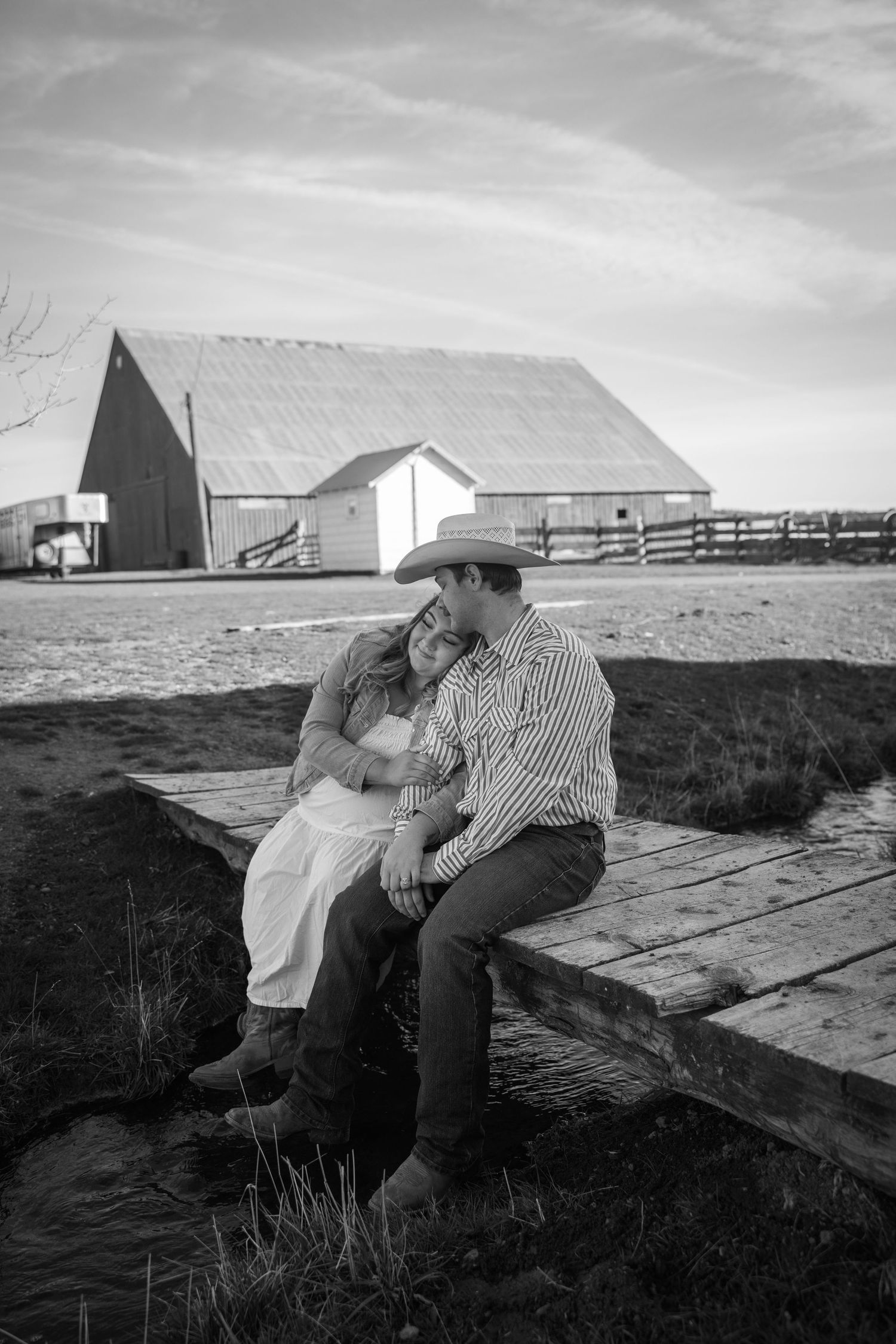 An intimate black and white photo series taken near a rustic barn structure.