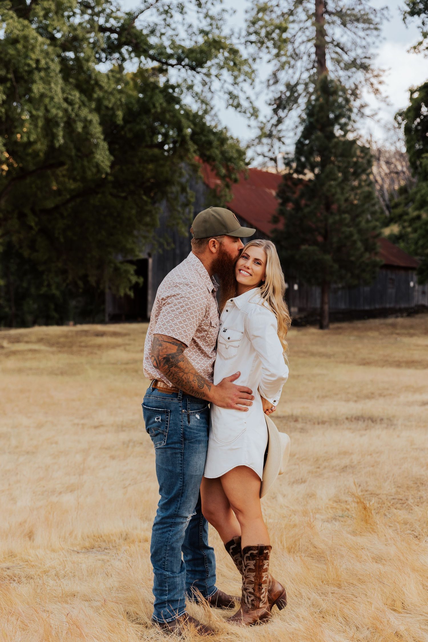 Romantic countryside photoshoot featuring tender moments near a vintage barn.