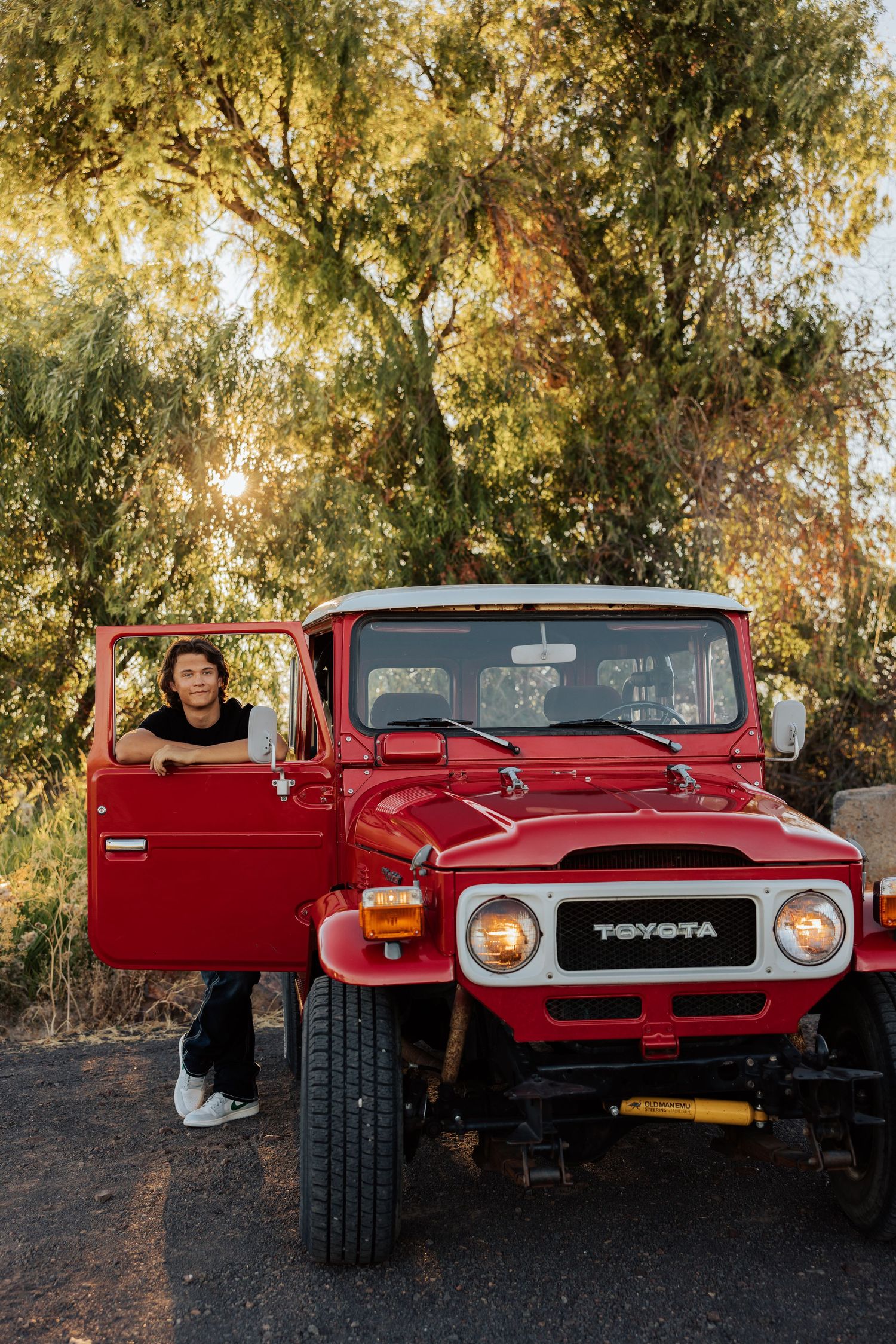 Front view of vintage red Toyota Land Cruiser with headlights and grill visible.