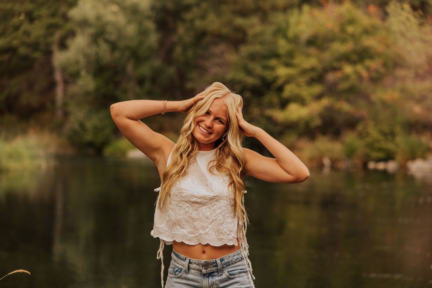 Golden hour portraits with autumn trees and lake reflections.