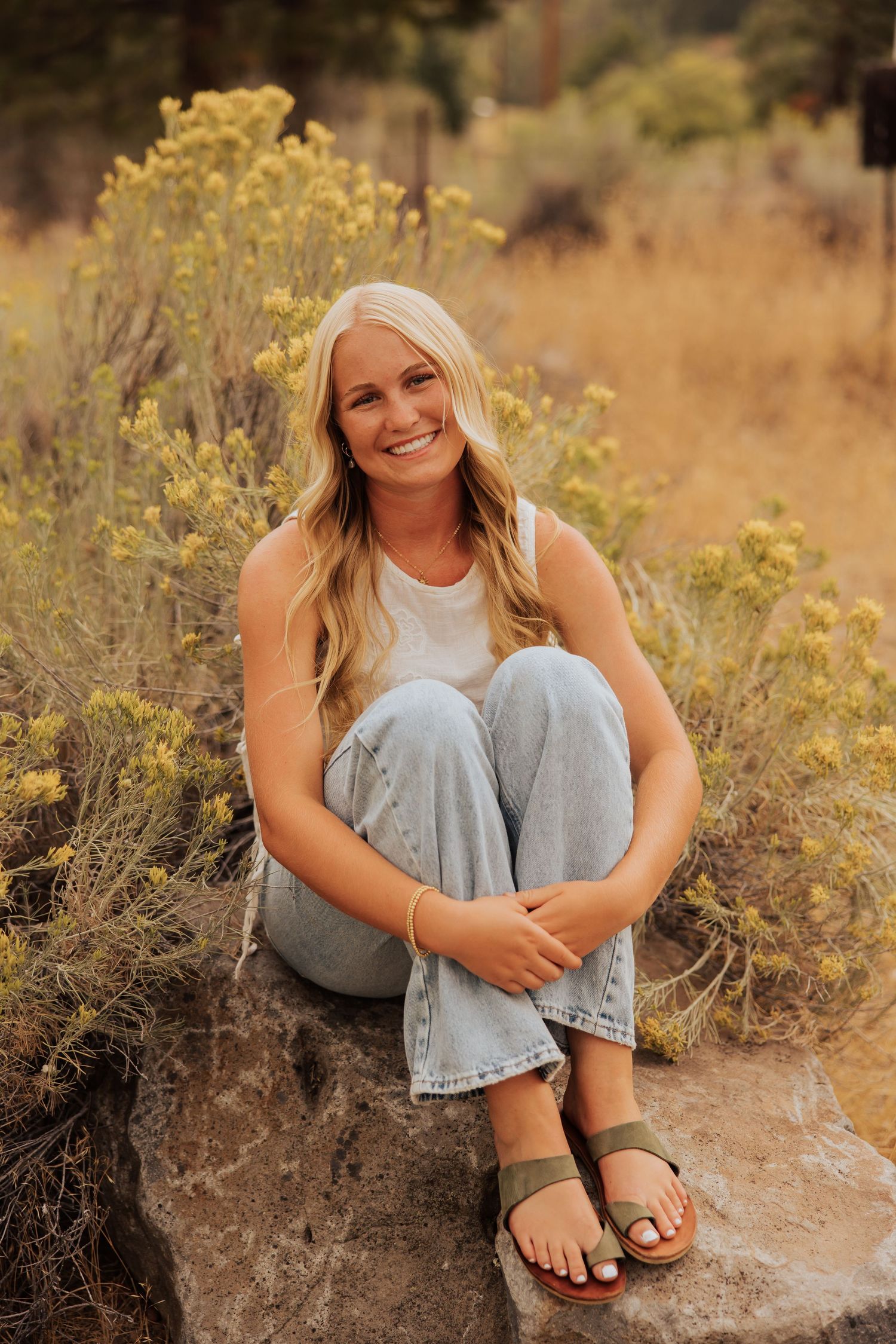 Desert-toned portrait session among yellow wildflowers and natural terrain.