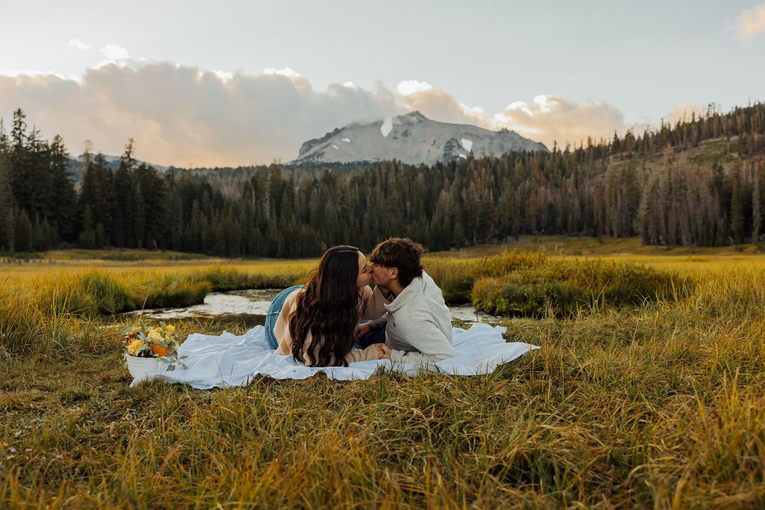 A scenic mountain landscape with winding river through golden meadows at sunset in Grand Teton National Park.