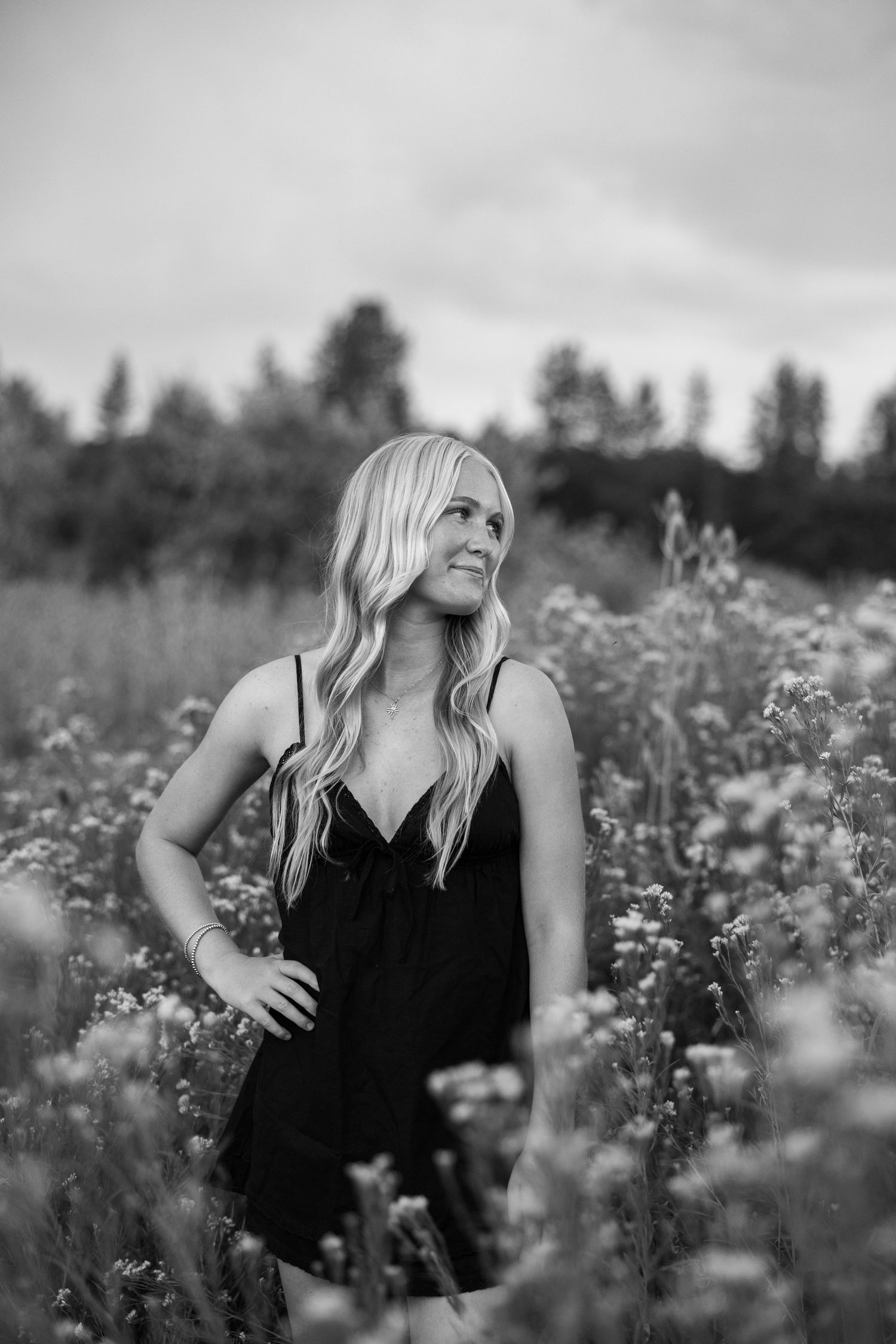 Artistic black and white portrait amidst a field of delicate wildflowers.