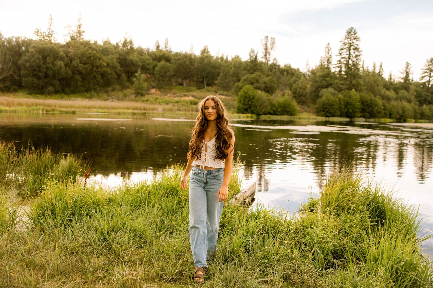 Nature-inspired photoshoot along a lakeside trail with mountain views in the distance.
