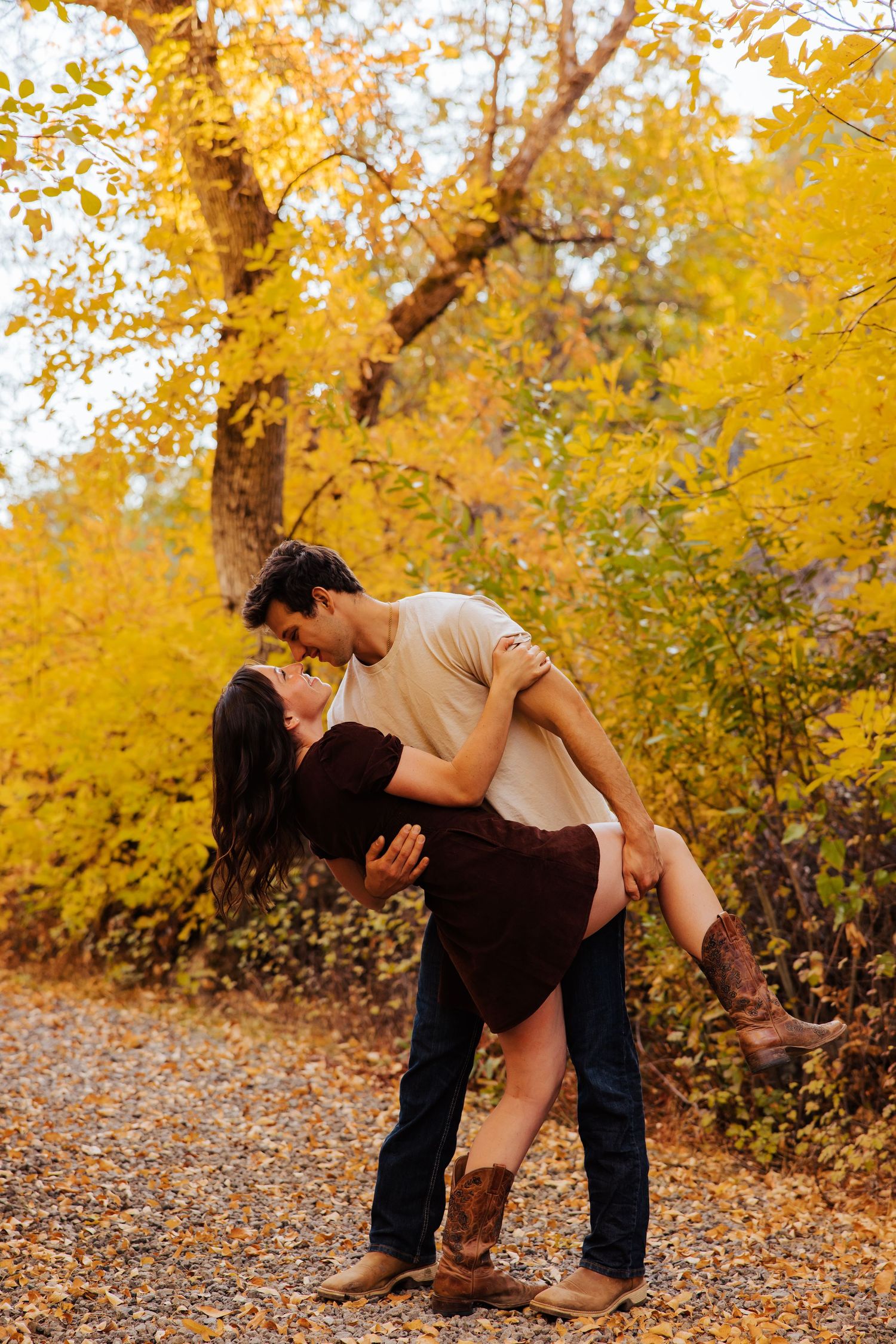 Romantic moment captured in autumn forest with golden leaves falling.