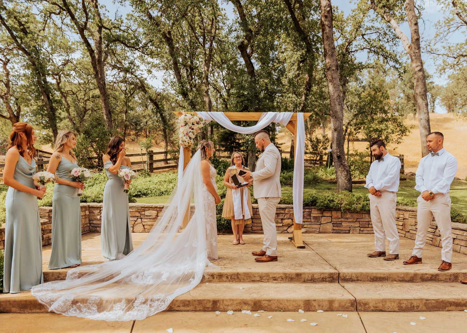 Wedding ceremony setup at an outdoor venue with white chairs and floral arrangements.