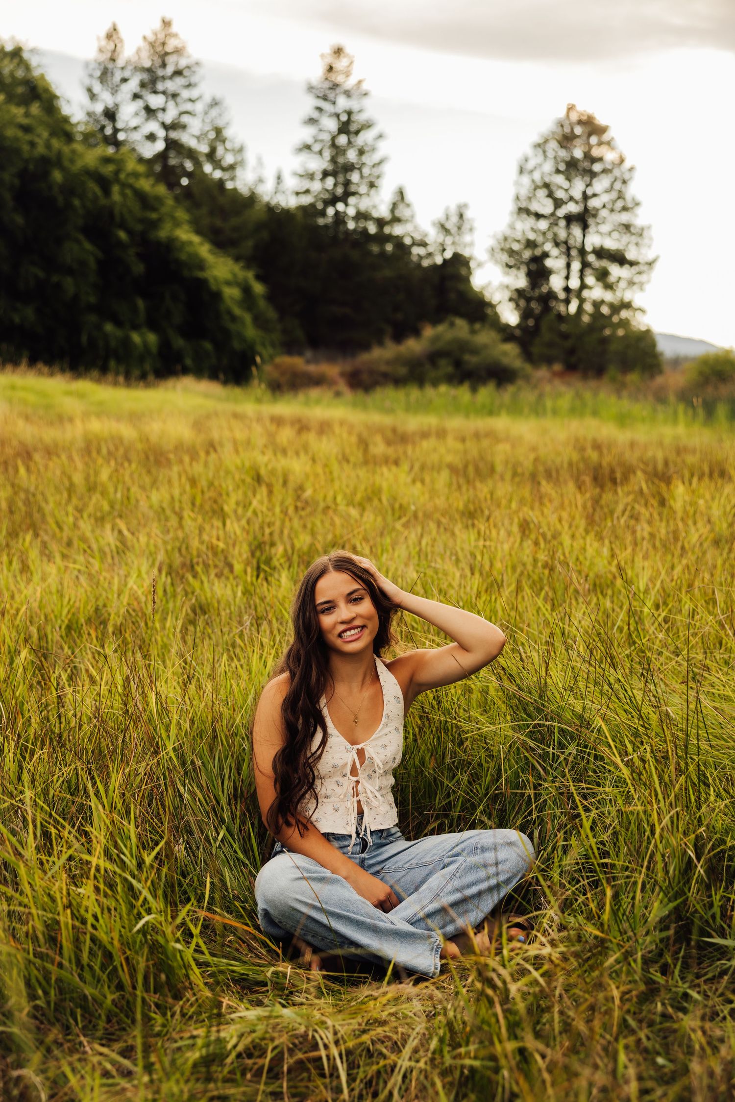 Natural outdoor portraits in a golden meadow with evergreen trees in the background.