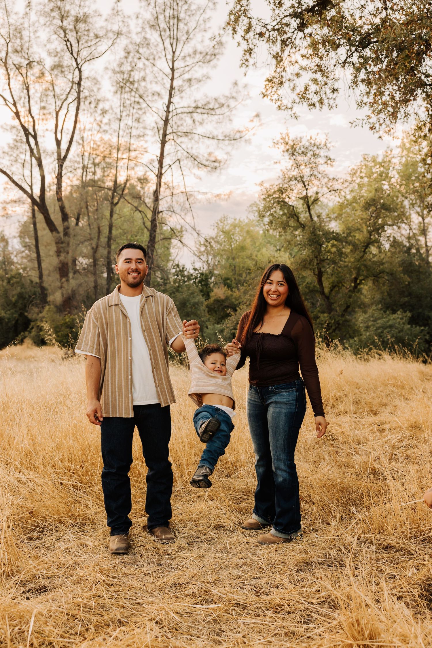 Group walks through autumn field wearing coordinated casual outfits during sunset.