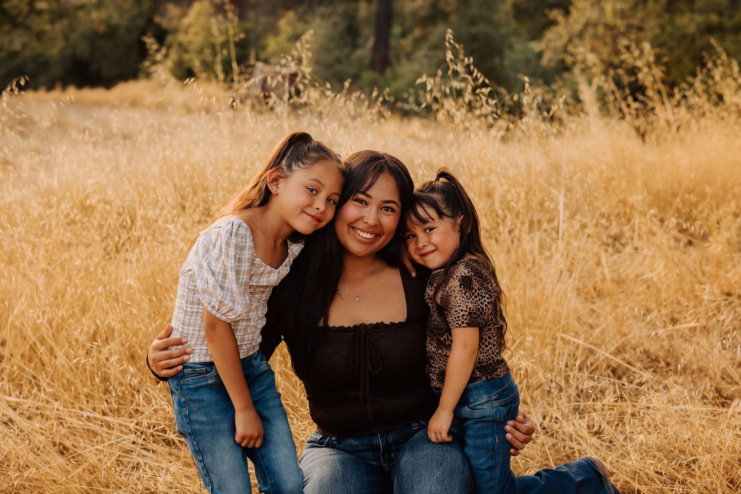 Family portrait session in a golden field during sunset with warm autumn colors.