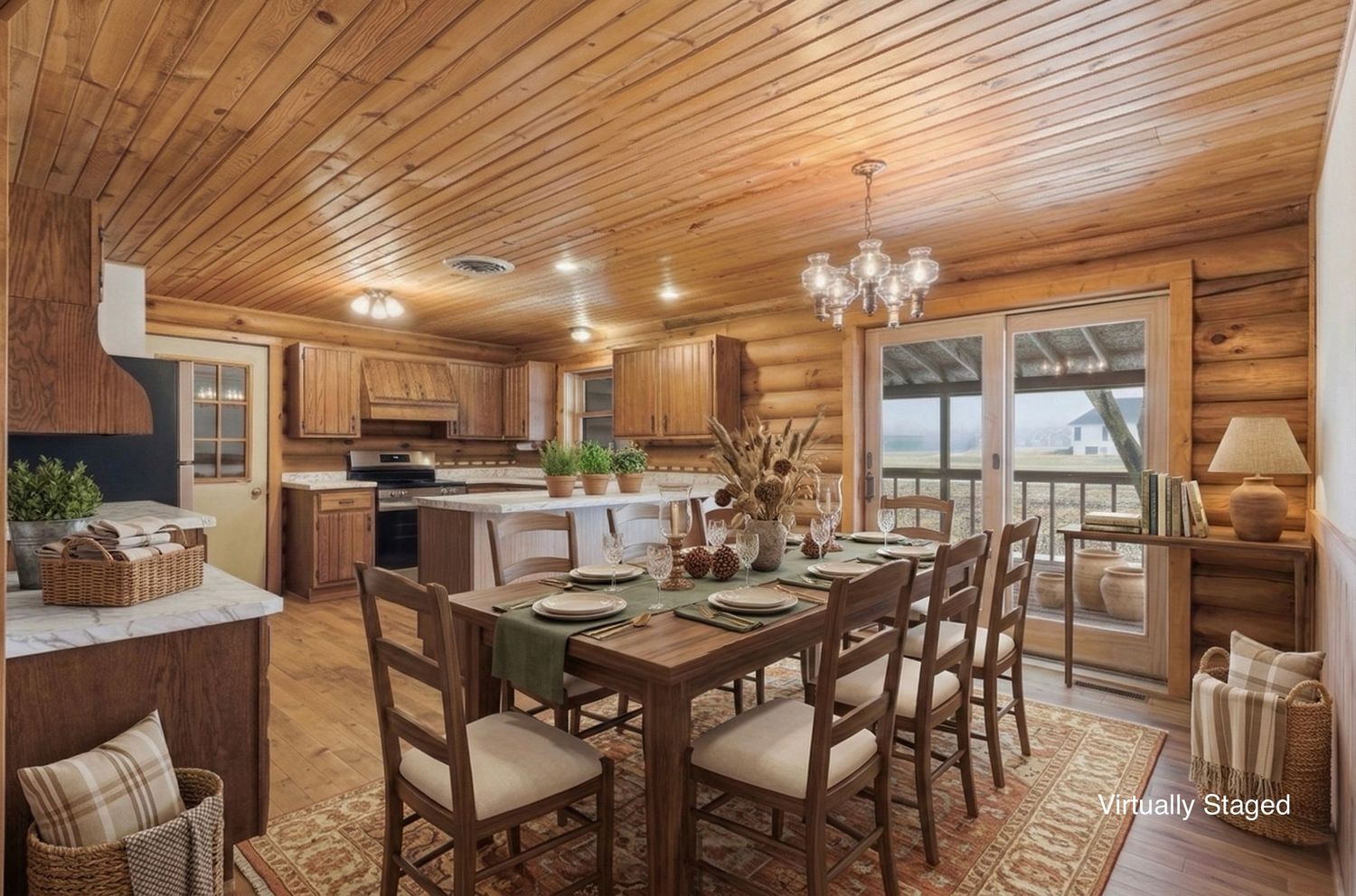 Rustic log cabin dining room and kitchen with wood paneled ceiling, chandelier, and large windows overlooking scenic views.