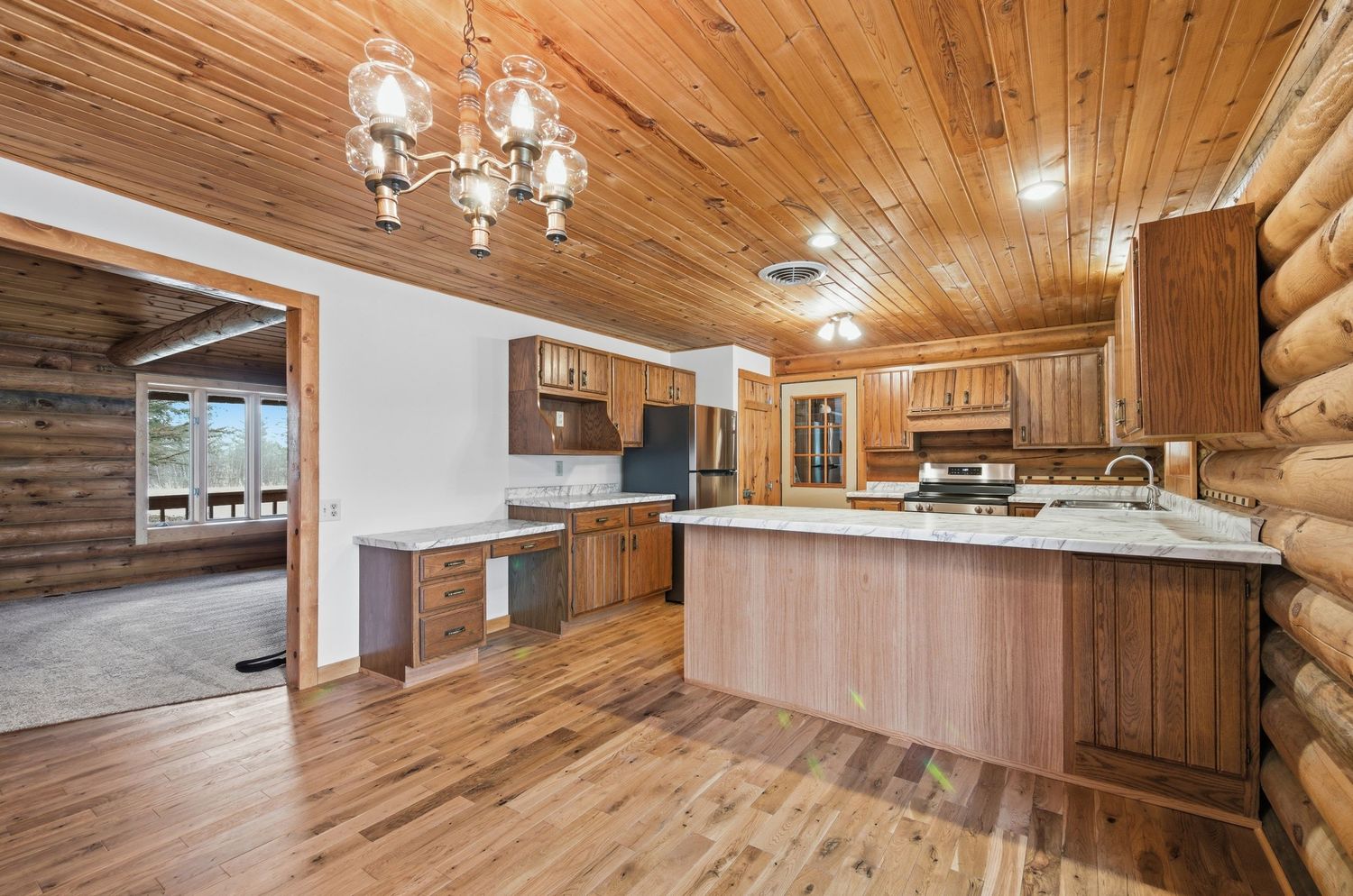 Modern basement with wood paneled ceiling and walls features built-in storage and recessed lighting throughout.