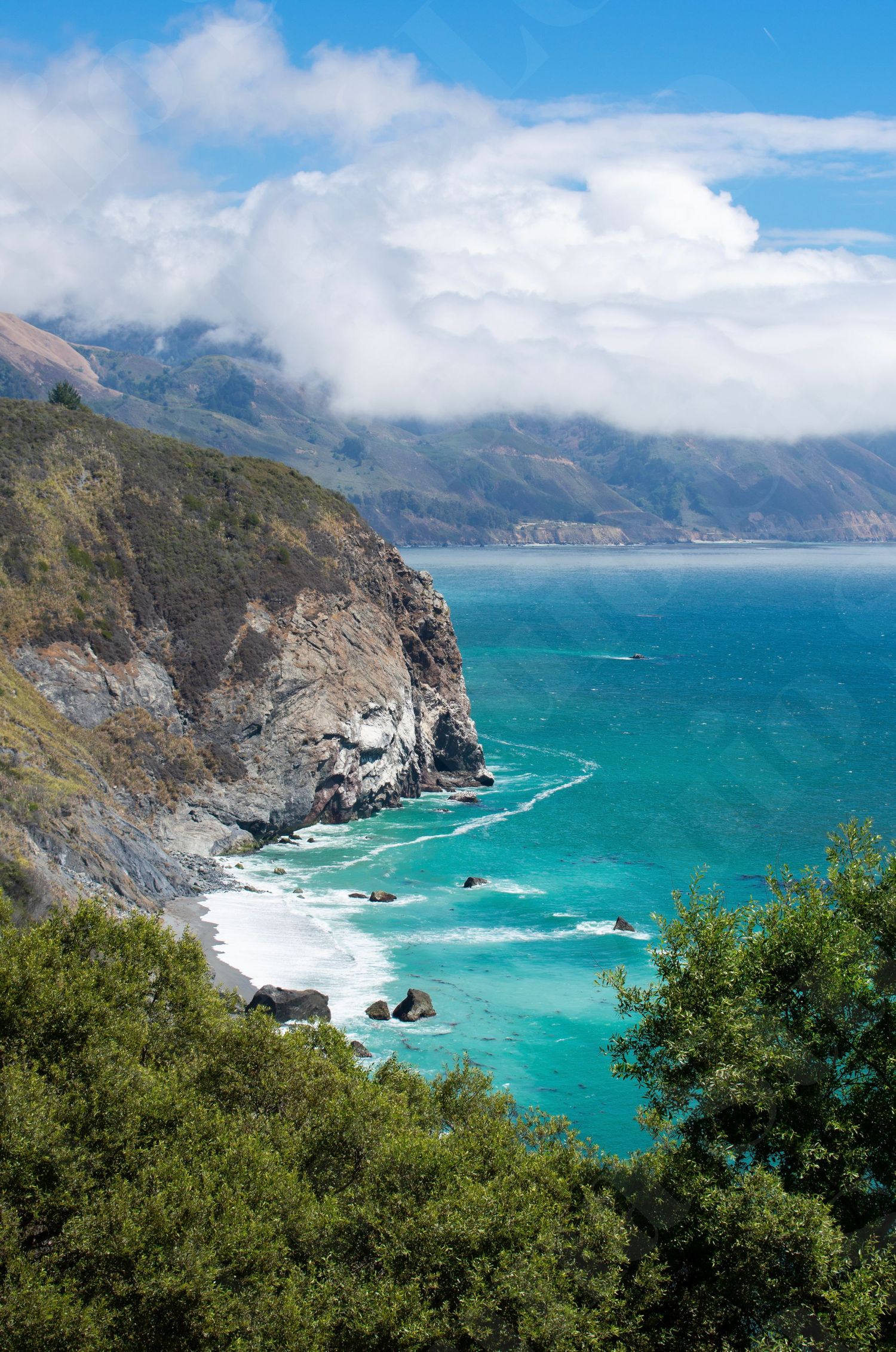 Dramatic coastal cliffs overlooking turquoise waters along Big Sur coastline.