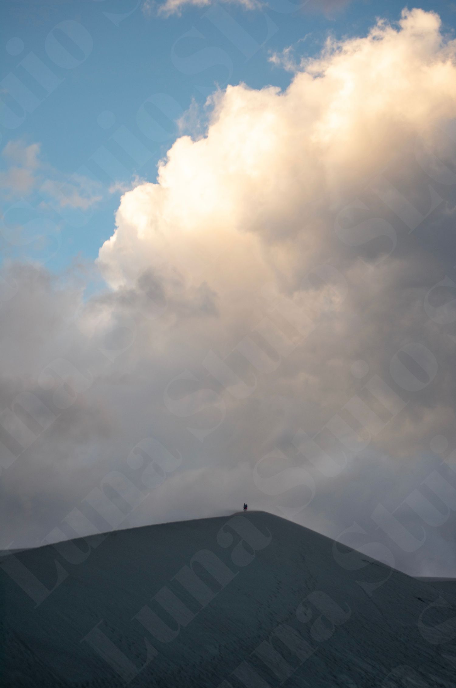 Dark mountain silhouette against a dramatic cloudy sky at dusk.