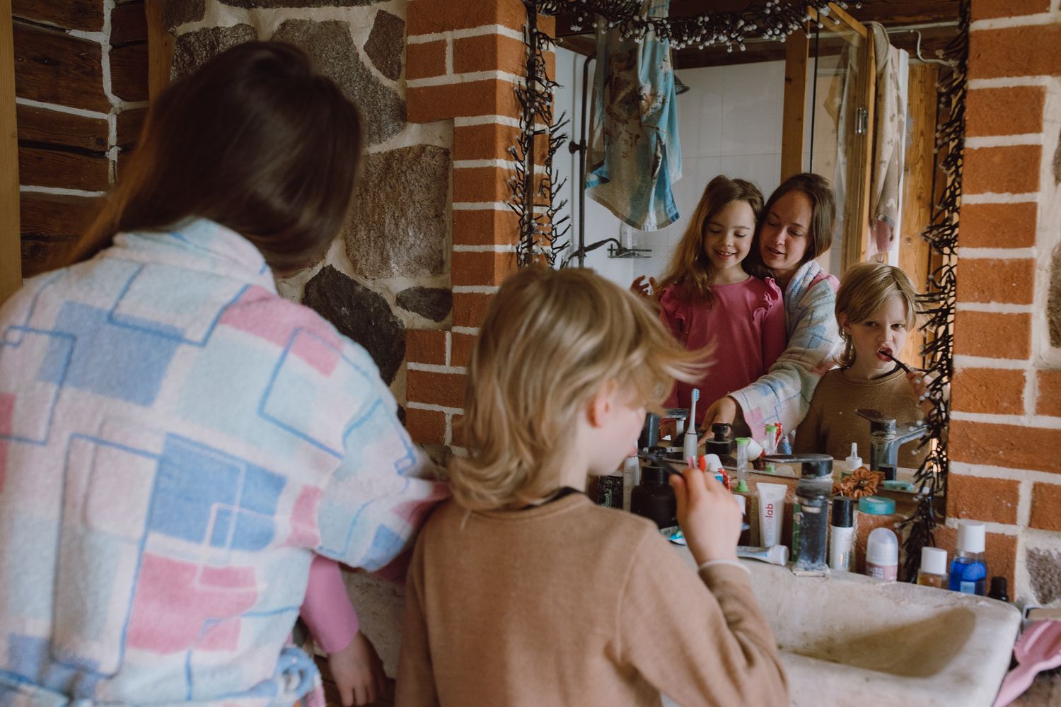 People gathered around a wooden table in a rustic brick-walled room.