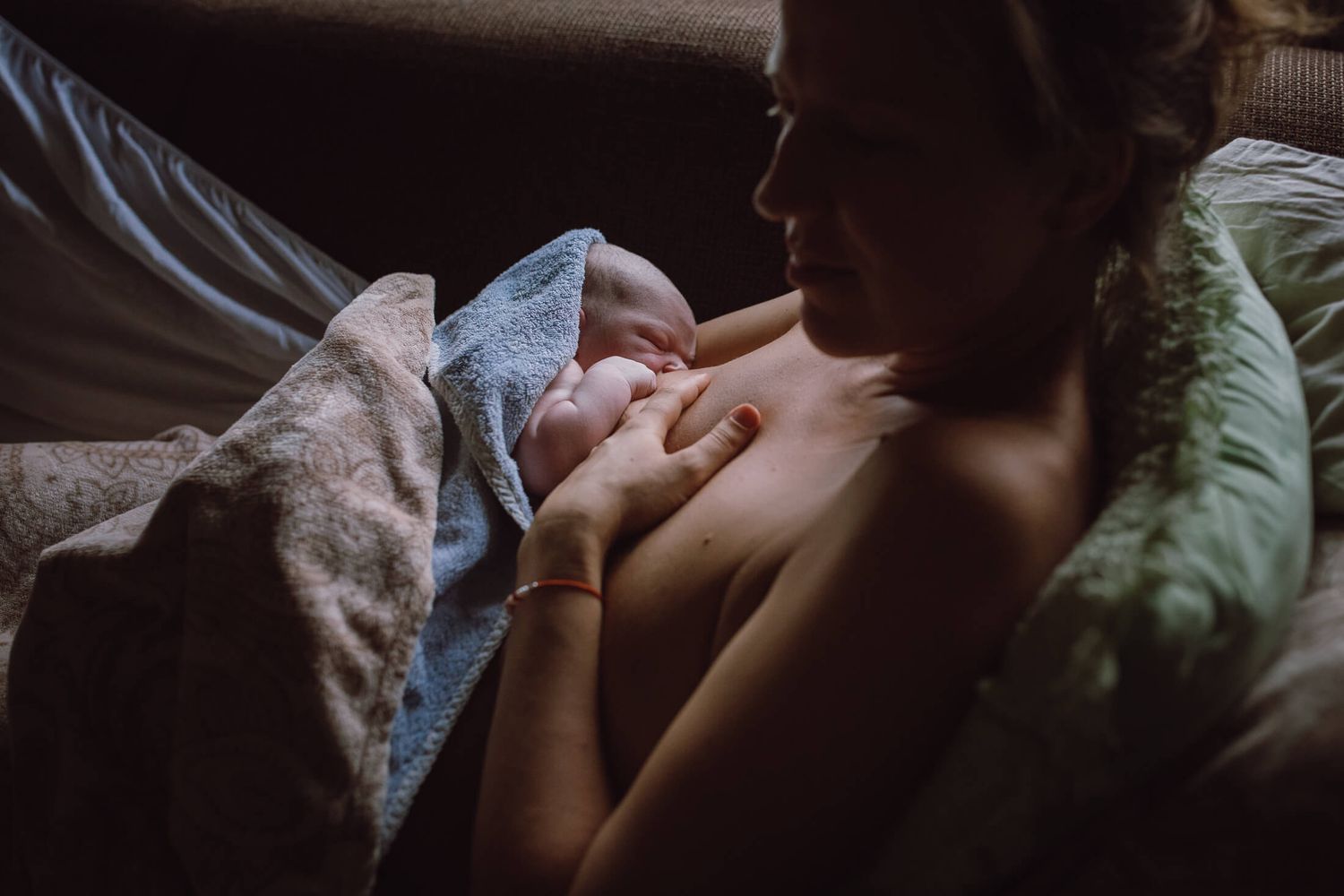 Intimate black and white portrait of tender parenting moments in soft window light.