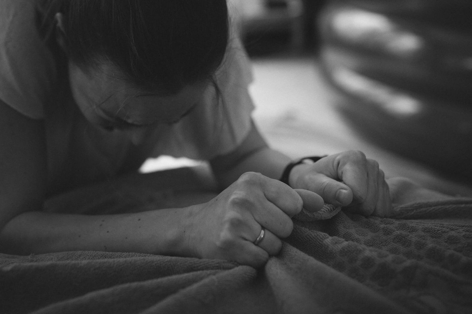 Close-up black and white details of hands and textures in low light.