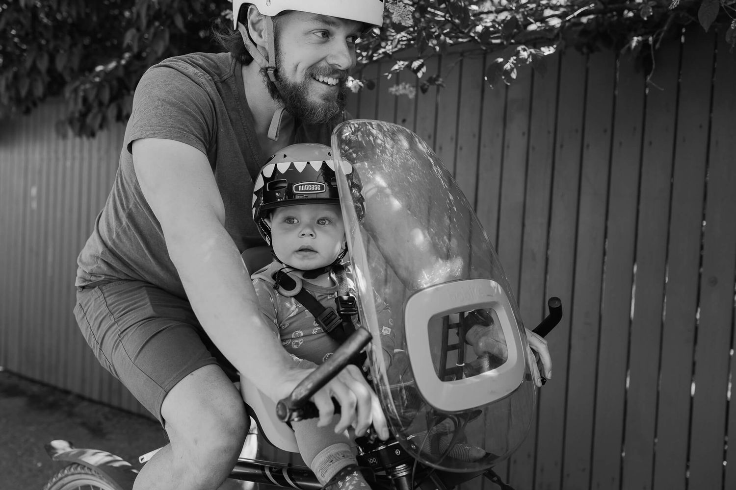 A black and white photo collage shows moments of a young child learning to ride a bicycle with adult assistance.