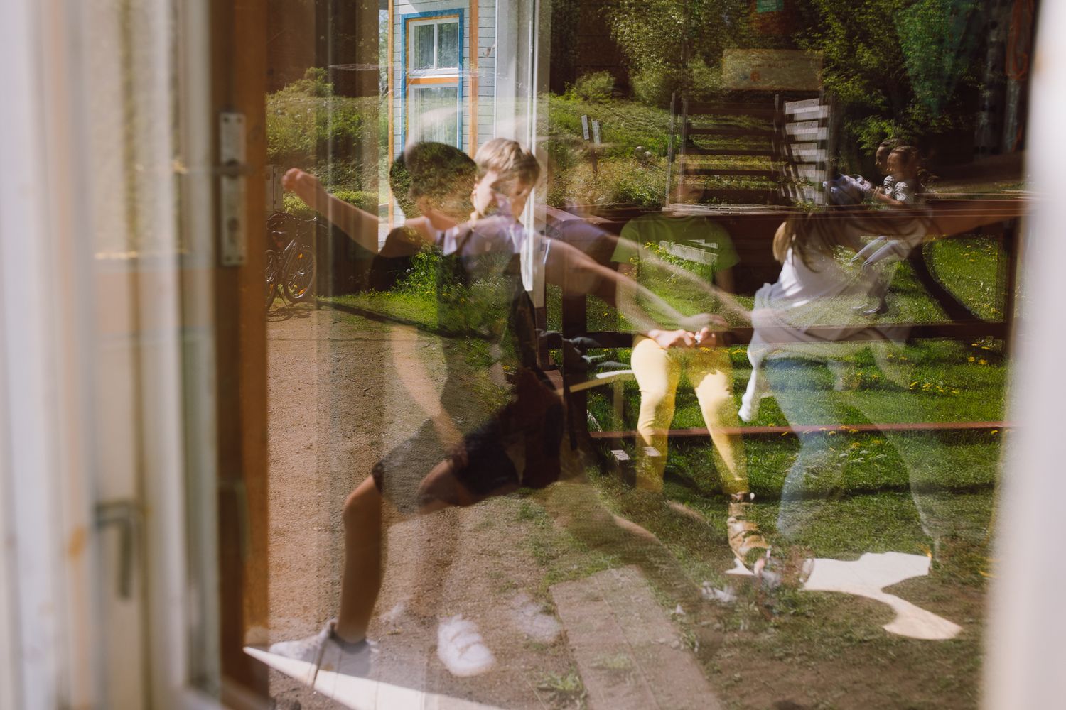 Motion blur of people walking through a bright interior space with reflective surfaces.