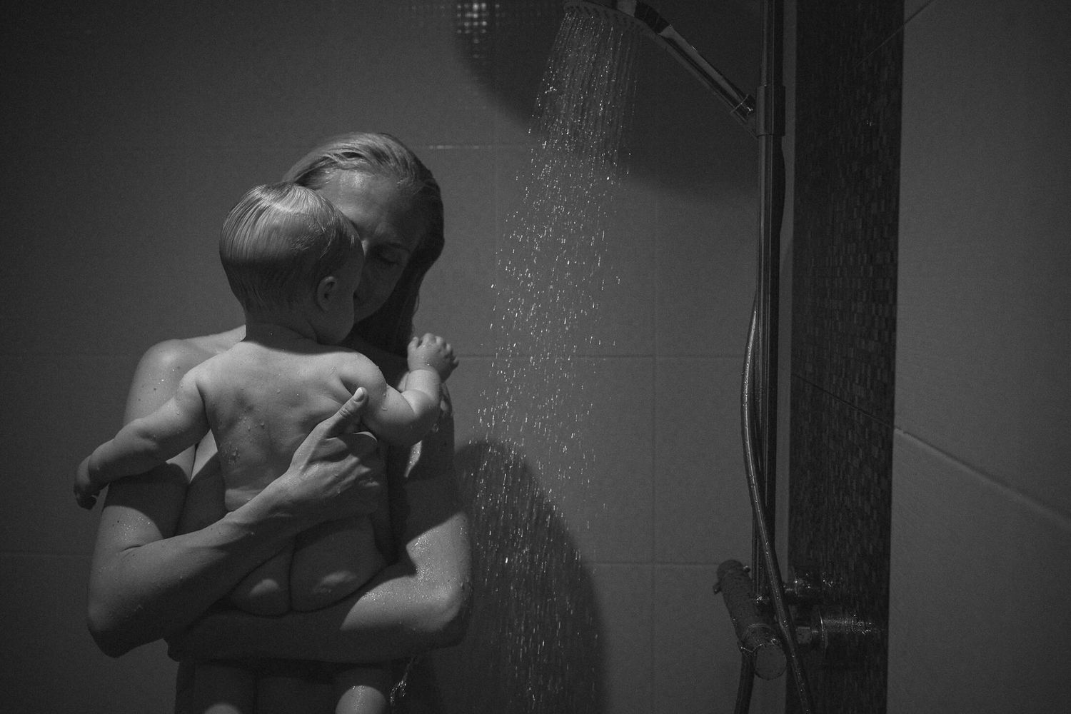 Dramatic black and white shower scene with water droplets and steam.