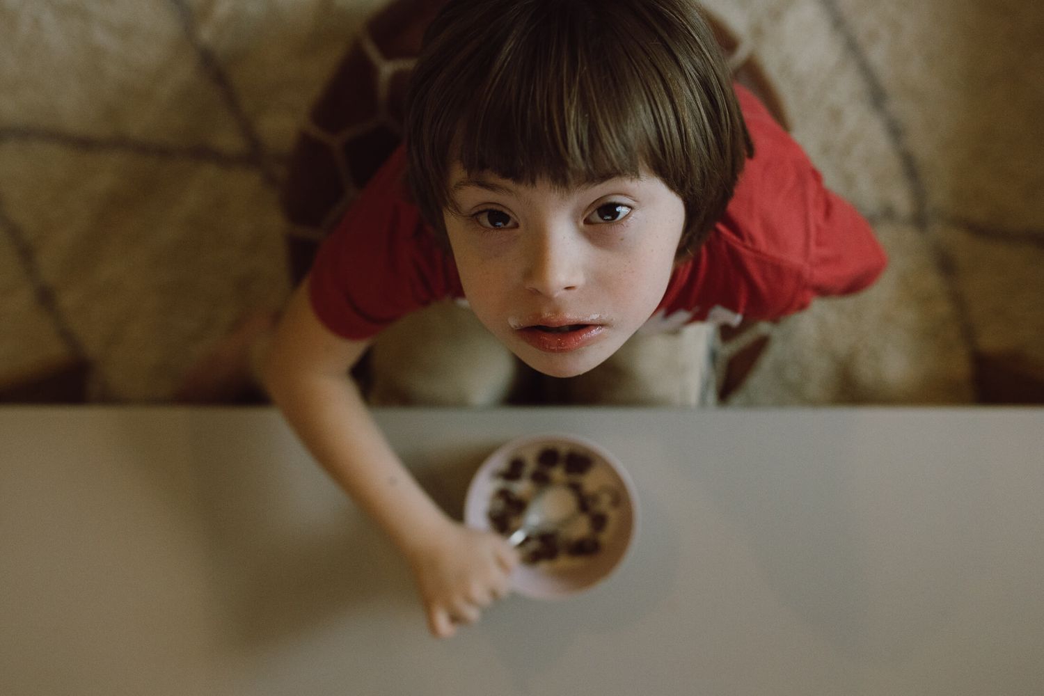 Overhead view of someone reaching for a small bowl on a table.