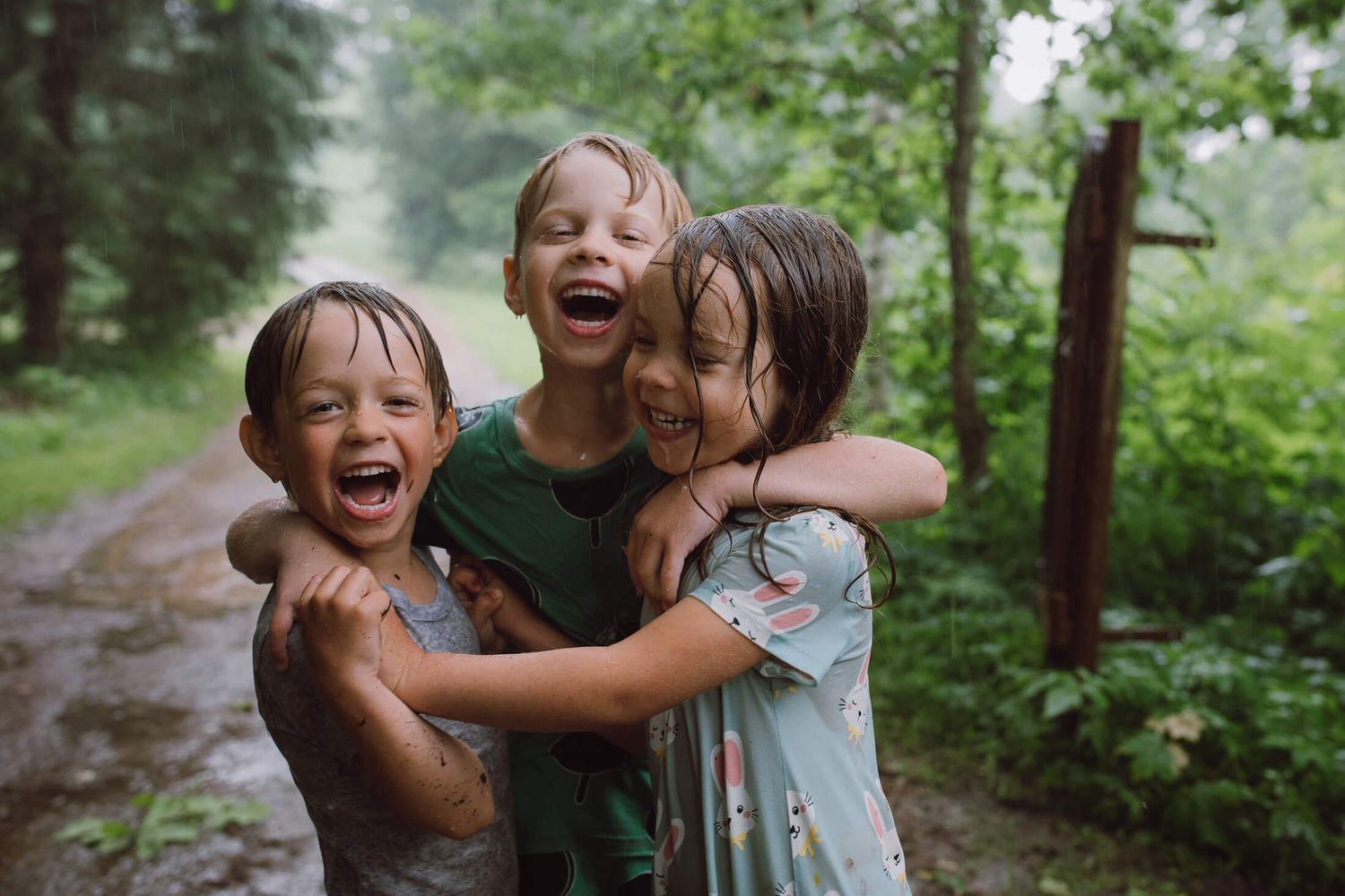 Children playing and laughing in a lush green forest setting.