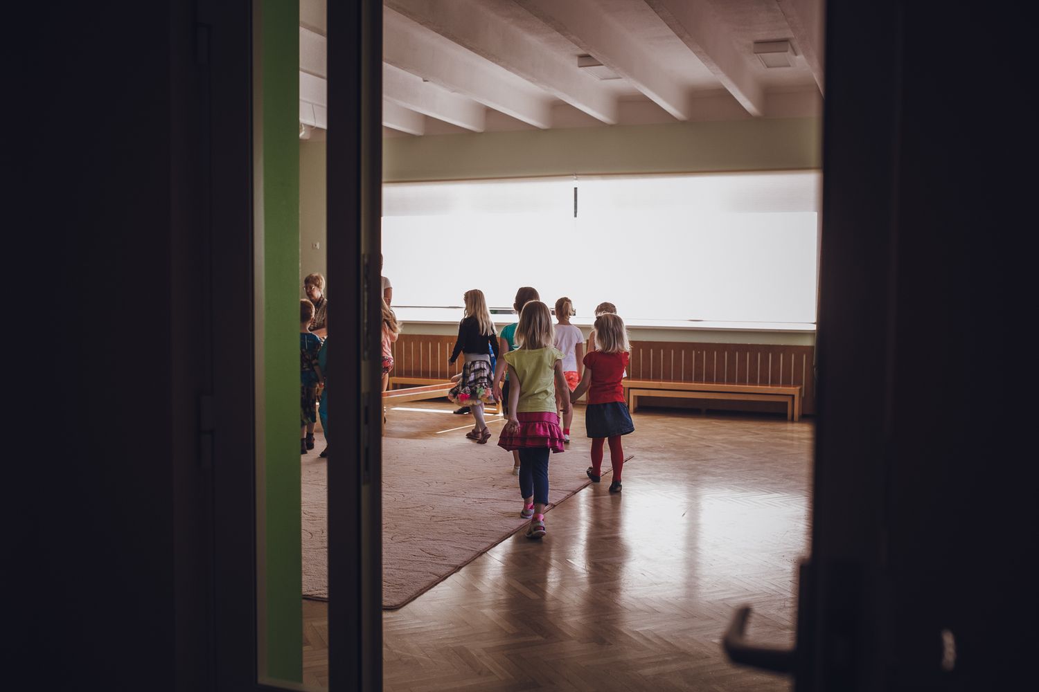 Dark interior hallway with silhouettes of people walking.