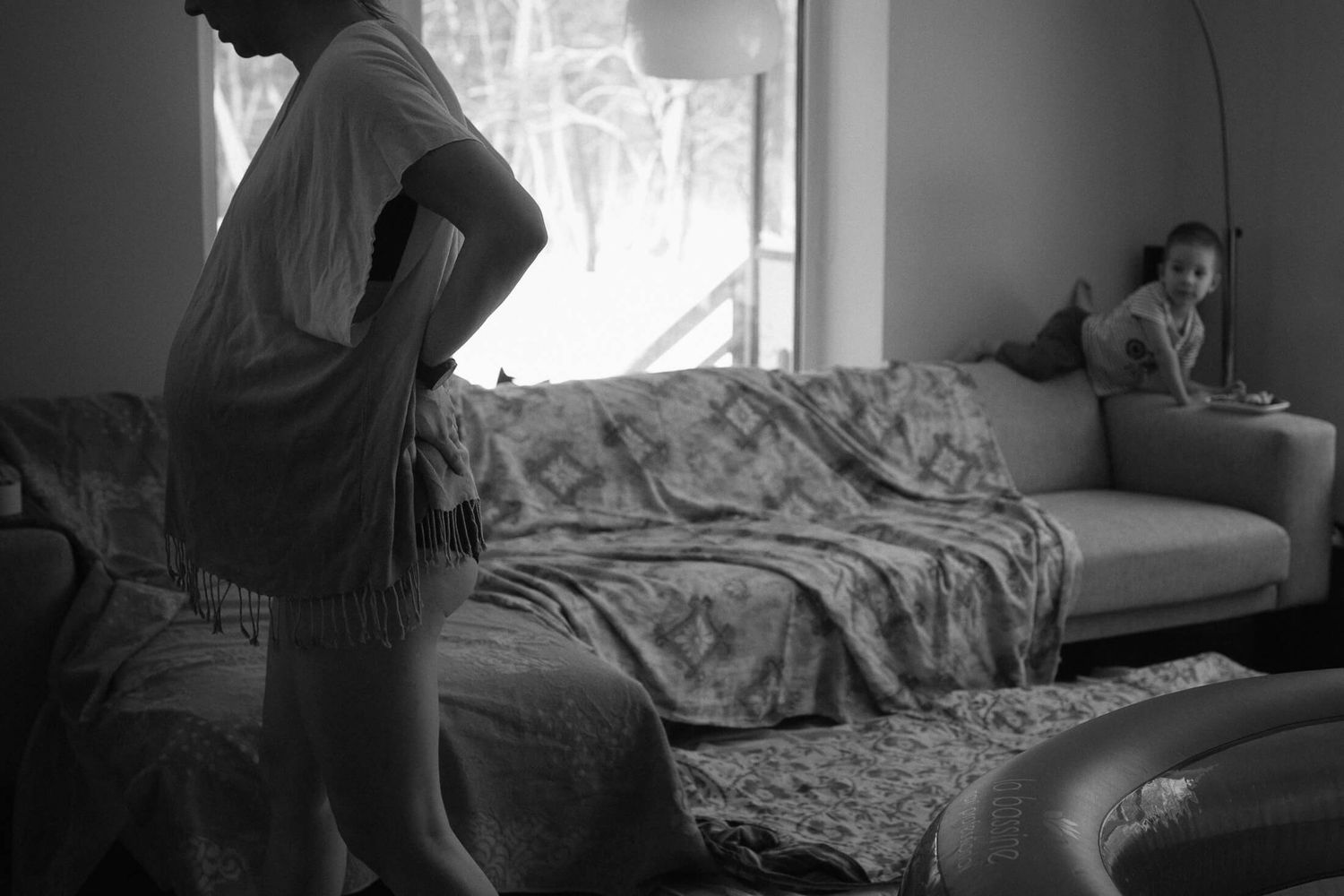 Silhouettes against window light in a bedroom setting with soft natural illumination.