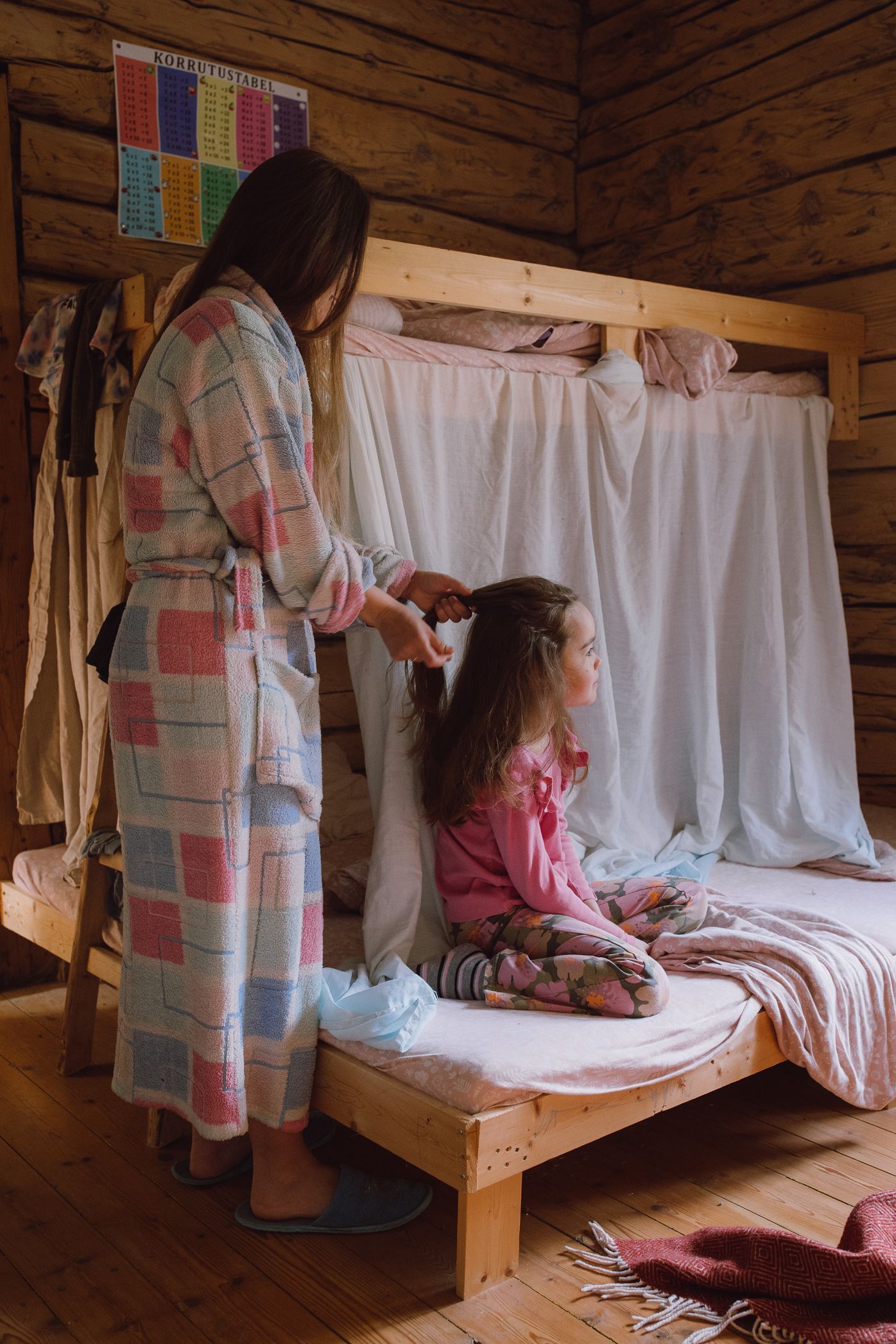 Cozy wooden bunk bed setup with white linens in a rustic cabin setting.