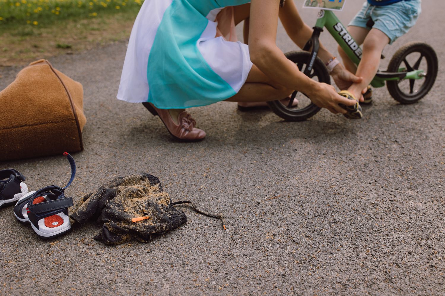 Children playing with toys on a paved driveway or sidewalk outdoors.