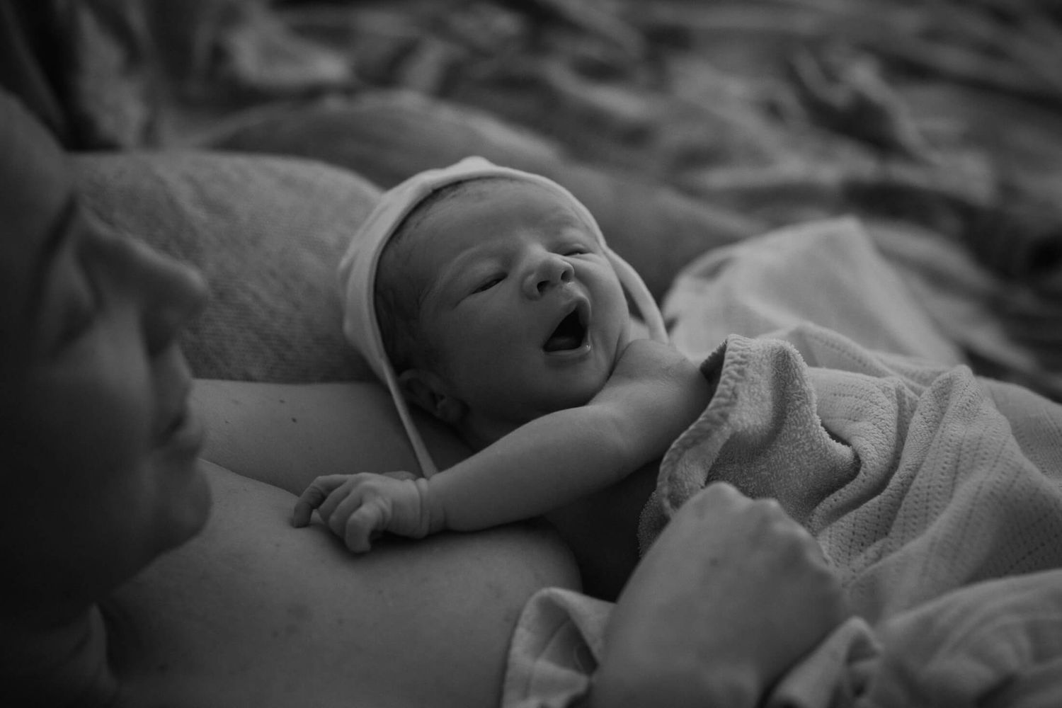 Black and white portrait of a newborn taking their first breaths.