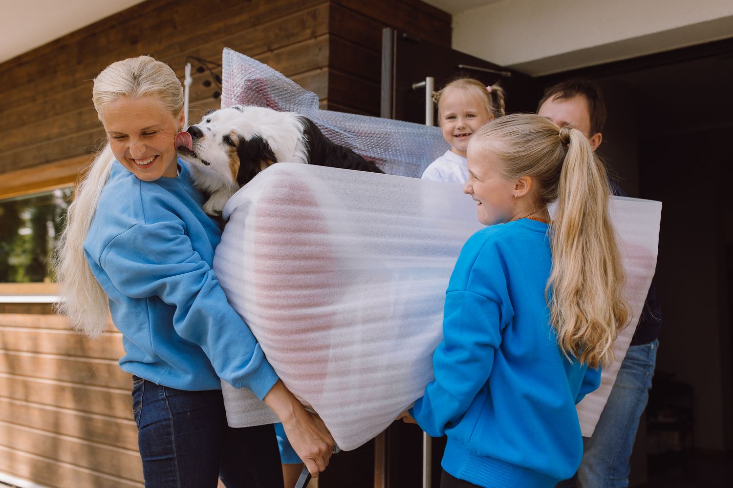 People in blue and white clothing interact playfully with fabric.