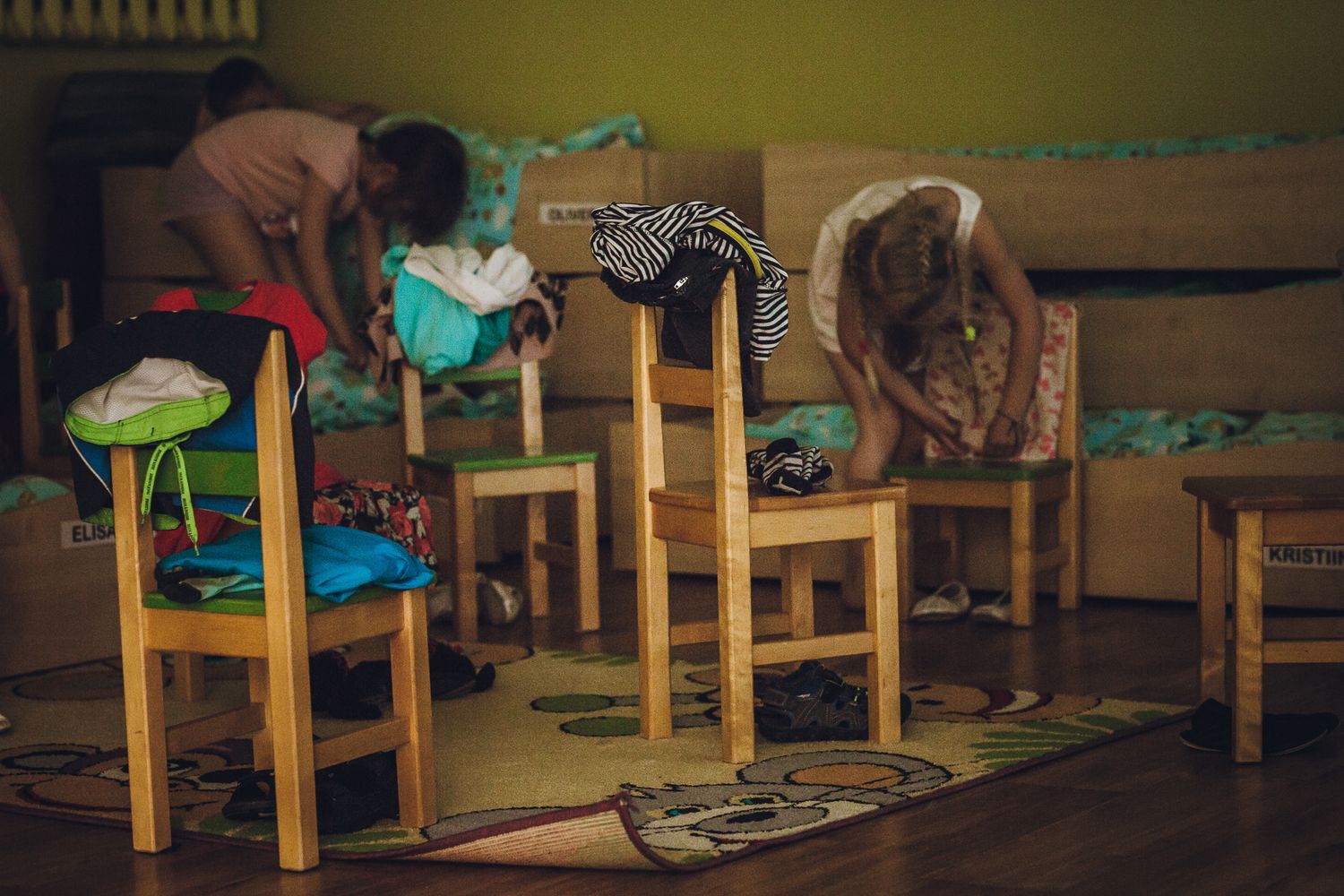 Wooden chairs arranged in a classroom with yellow walls.