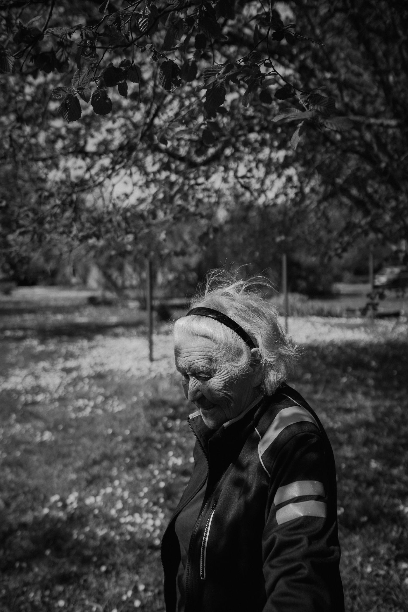 A black and white photo series shows people enjoying a windy autumn day in a park setting.