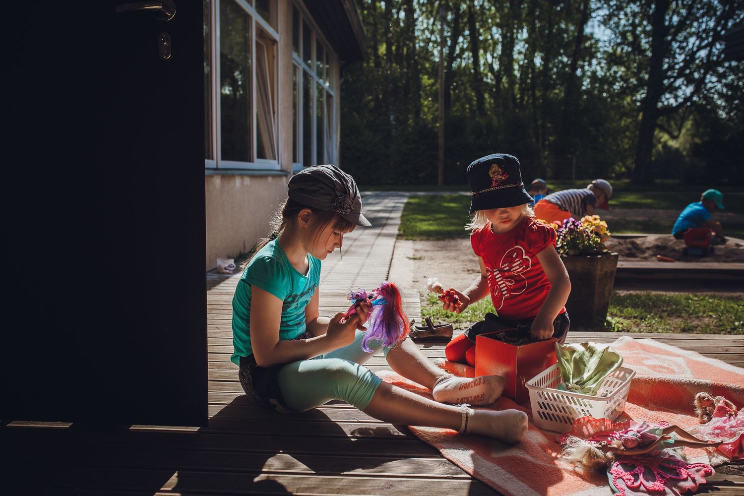 Children engaged in outdoor crafting activities at tables on a sunny day.