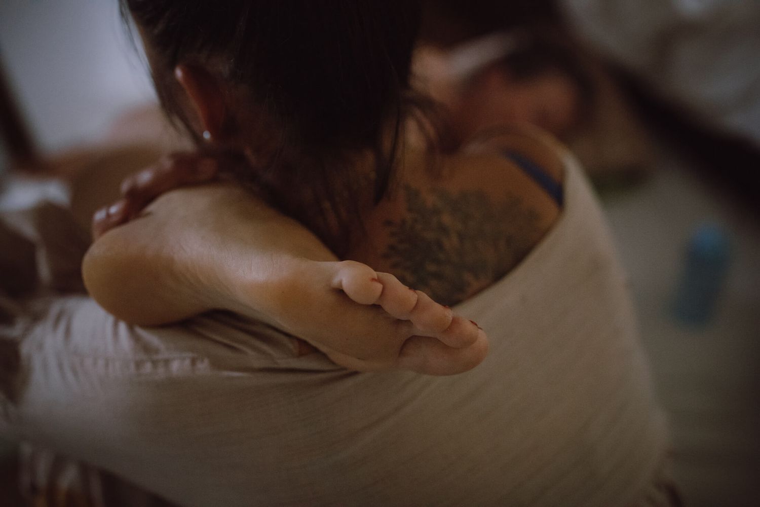 Intimate black and white photo showing supportive touch during a birth experience.