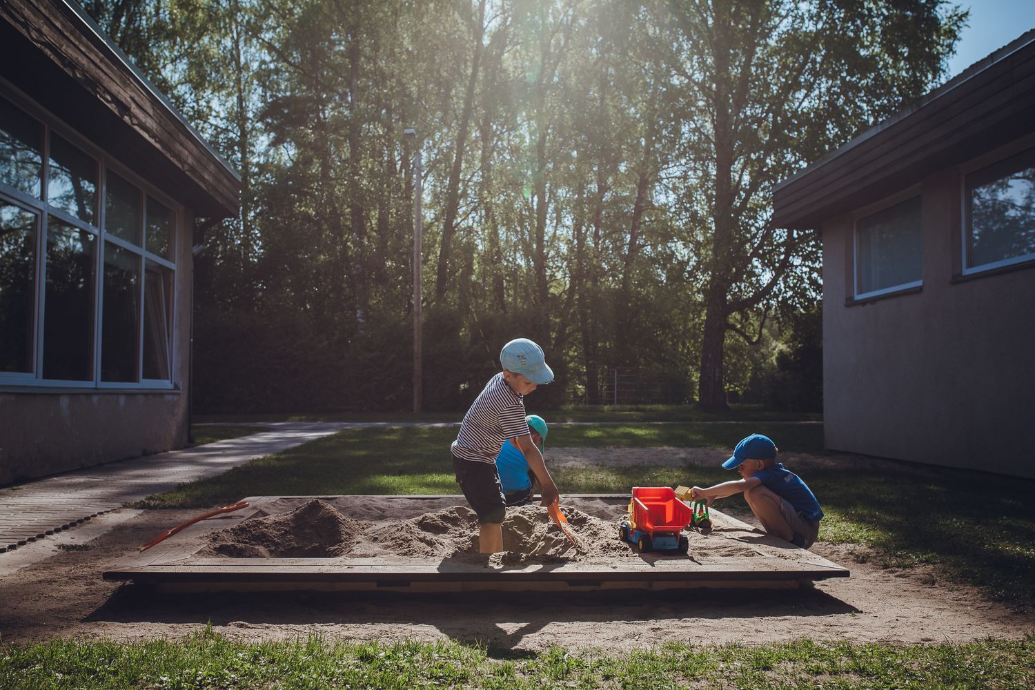 Sunlit outdoor scene with people gathered near a building.