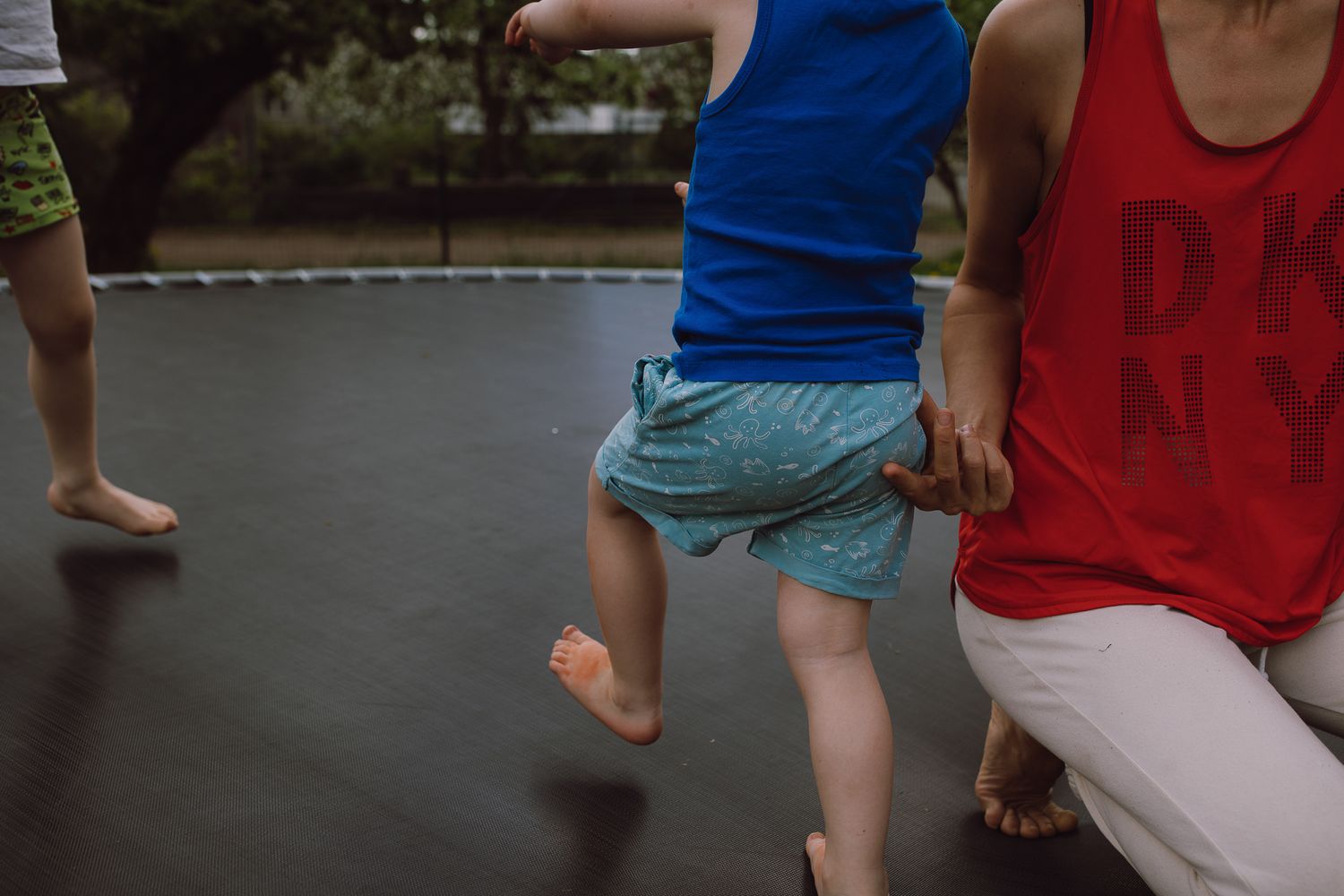 Group of people walking and playing on an outdoor court or playground.