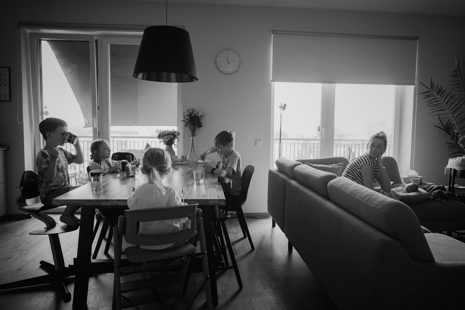 A series of black and white silhouettes show people working in a modern office space with natural lighting.
