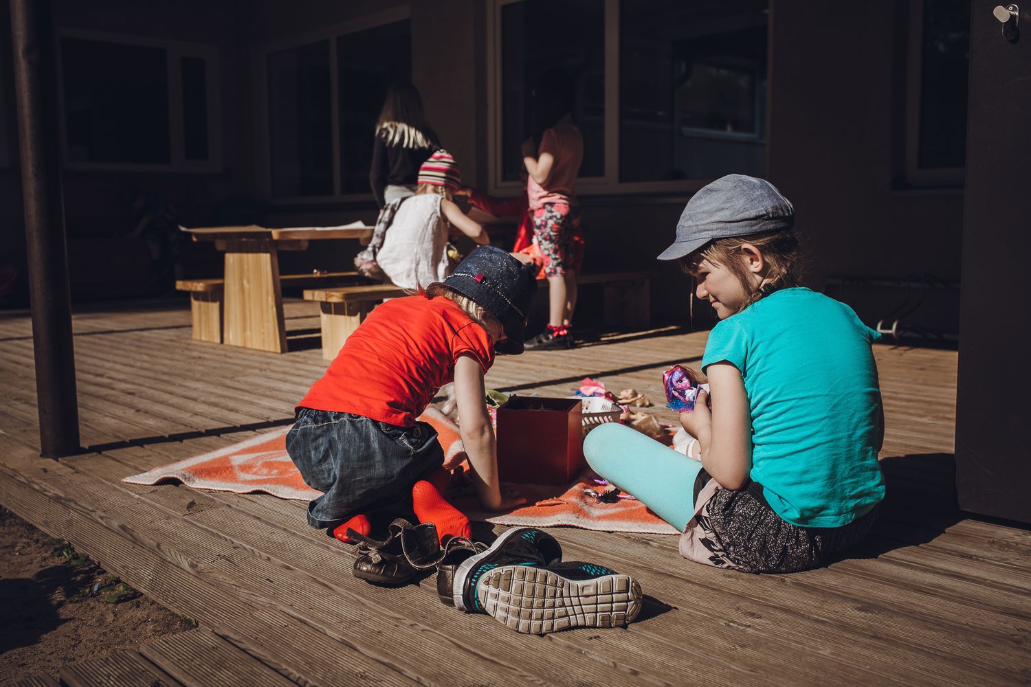 People sitting together on wooden decking in an outdoor space.